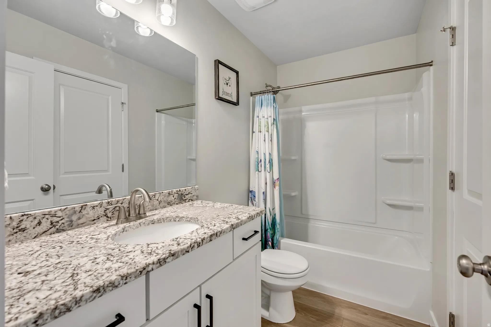 Guest bathroom with tub/shower combo and granite countertop vanity.