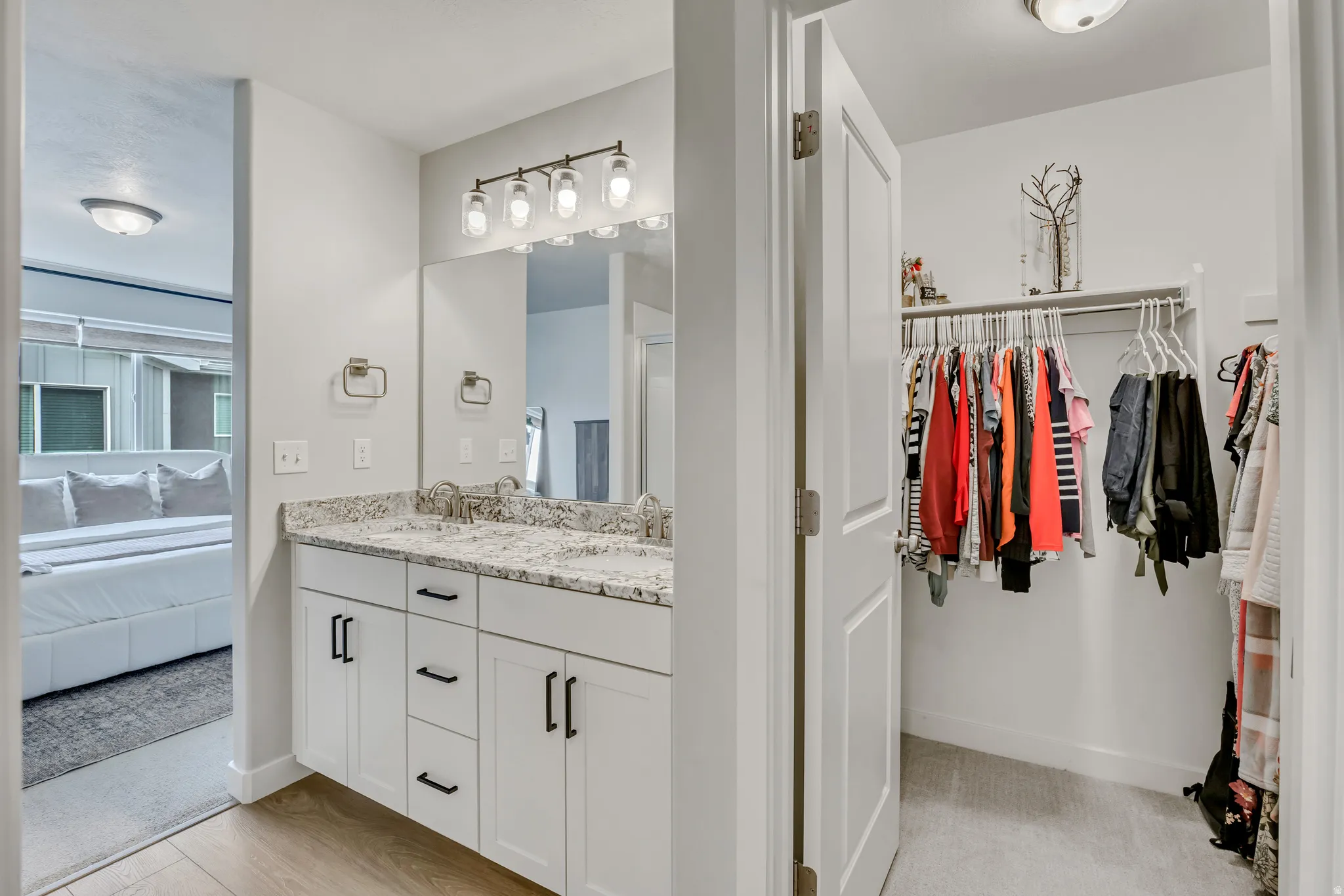 Ensuite bathroom featuring a walk in closet and double vanity.