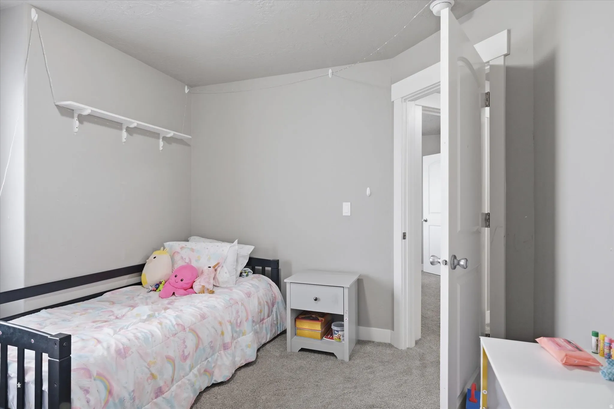 Bedroom with light carpet and a textured ceiling