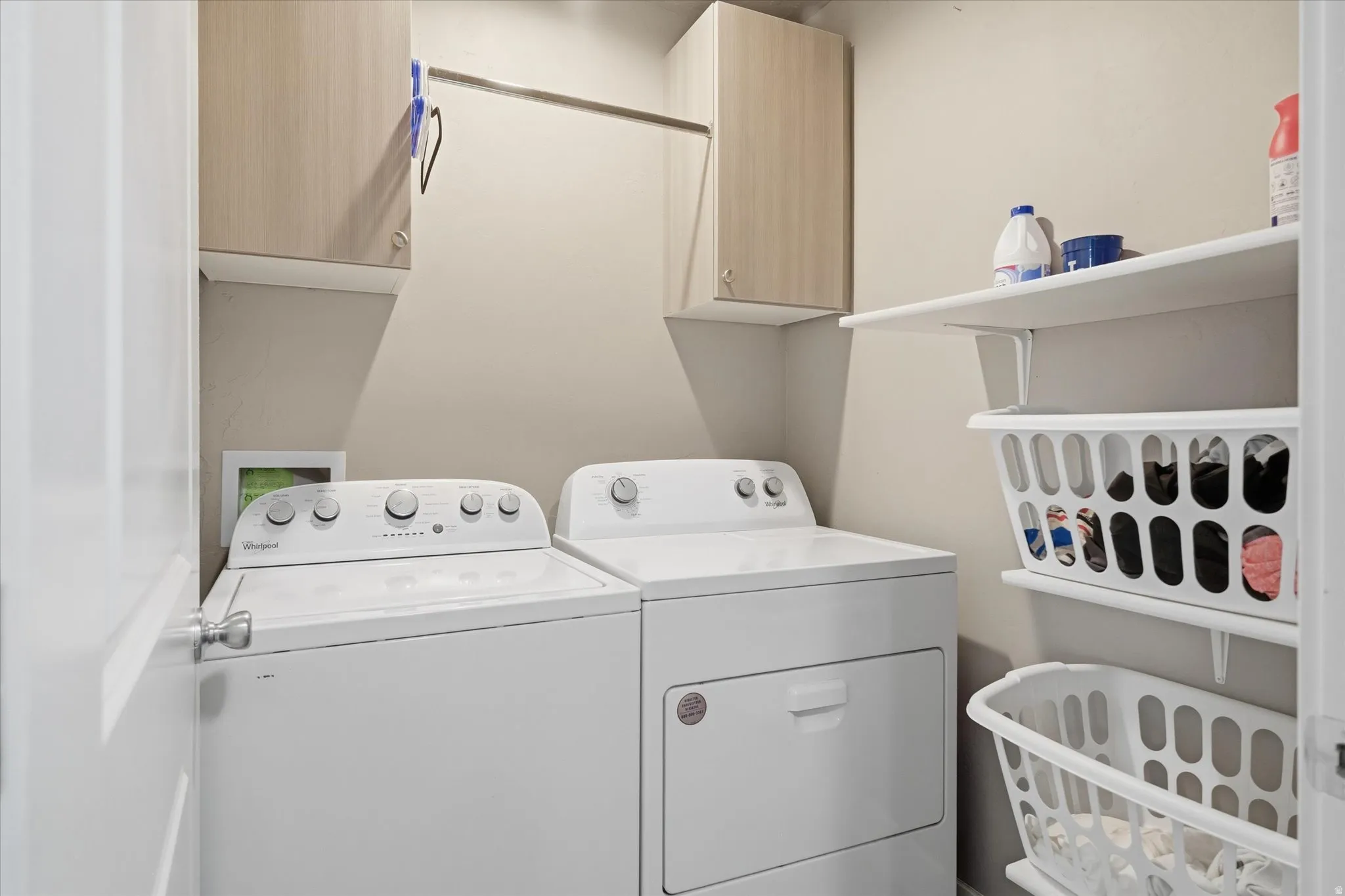 Laundry room featuring washer and clothes dryer and cabinet space