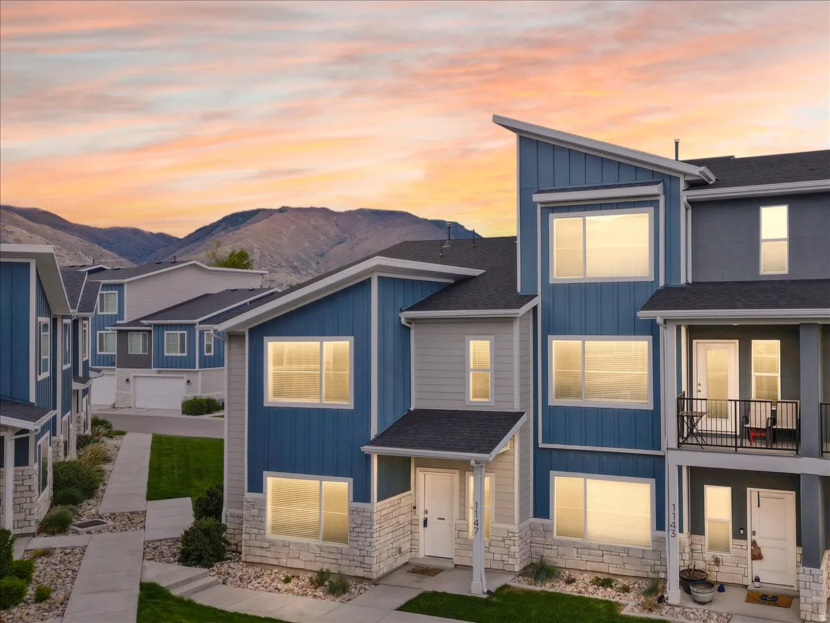 View of front of property featuring board and batten siding, stone siding, and roof with shingles
