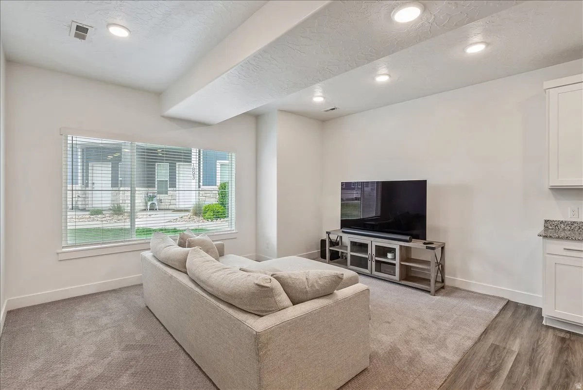 Living area featuring a textured ceiling, recessed lighting, and light wood finished floors