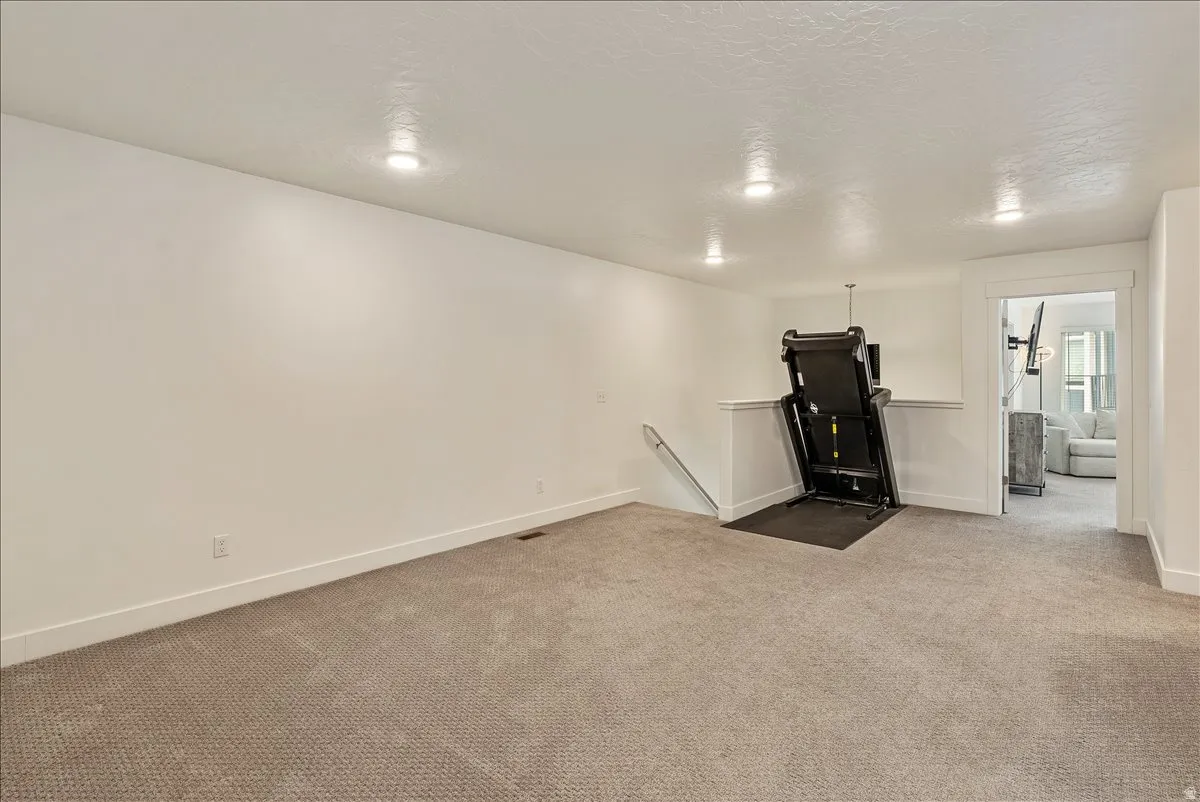 Unfurnished living room featuring carpet floors and a textured ceiling