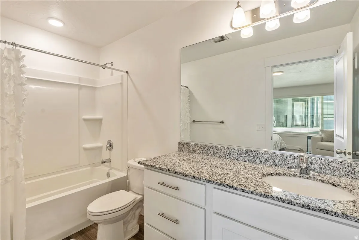 Ensuite bathroom featuring vanity and shower / bath combo with shower curtain