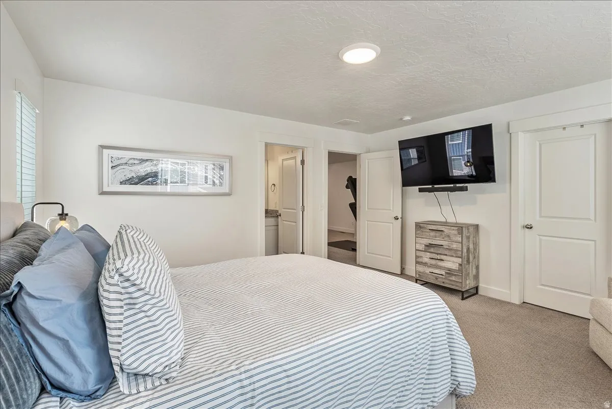 Carpeted bedroom with baseboards and a textured ceiling