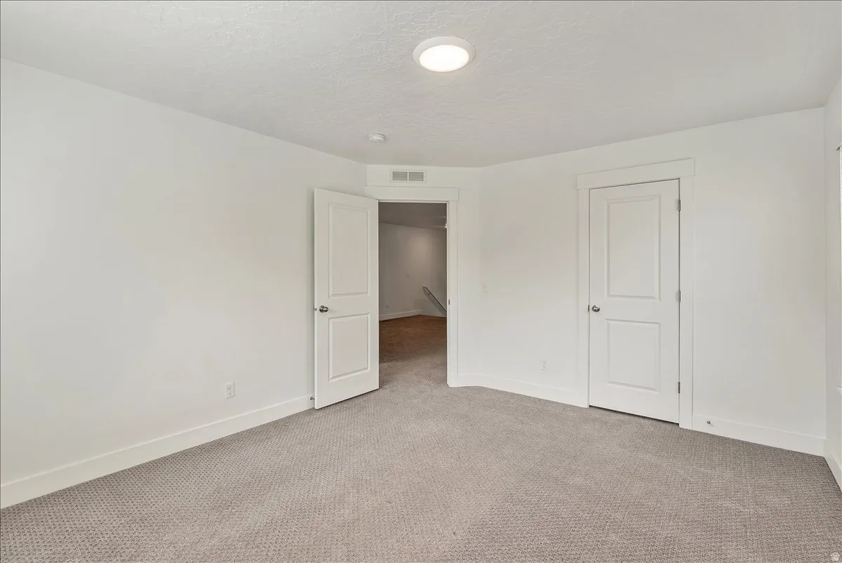 Unfurnished bedroom featuring carpet and a textured ceiling