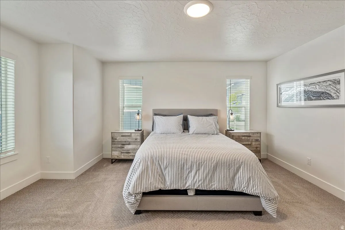 Bedroom featuring a textured ceiling and light carpet