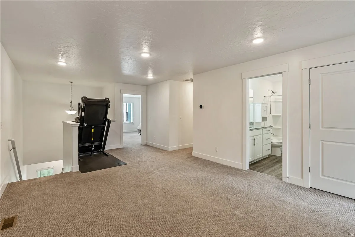 Unfurnished office with a textured ceiling and light carpet