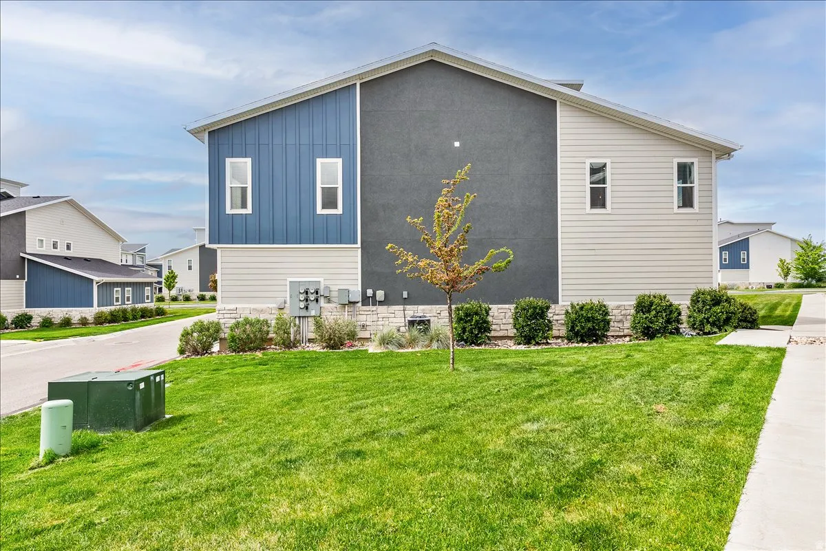 View of property exterior with a yard and board and batten siding
