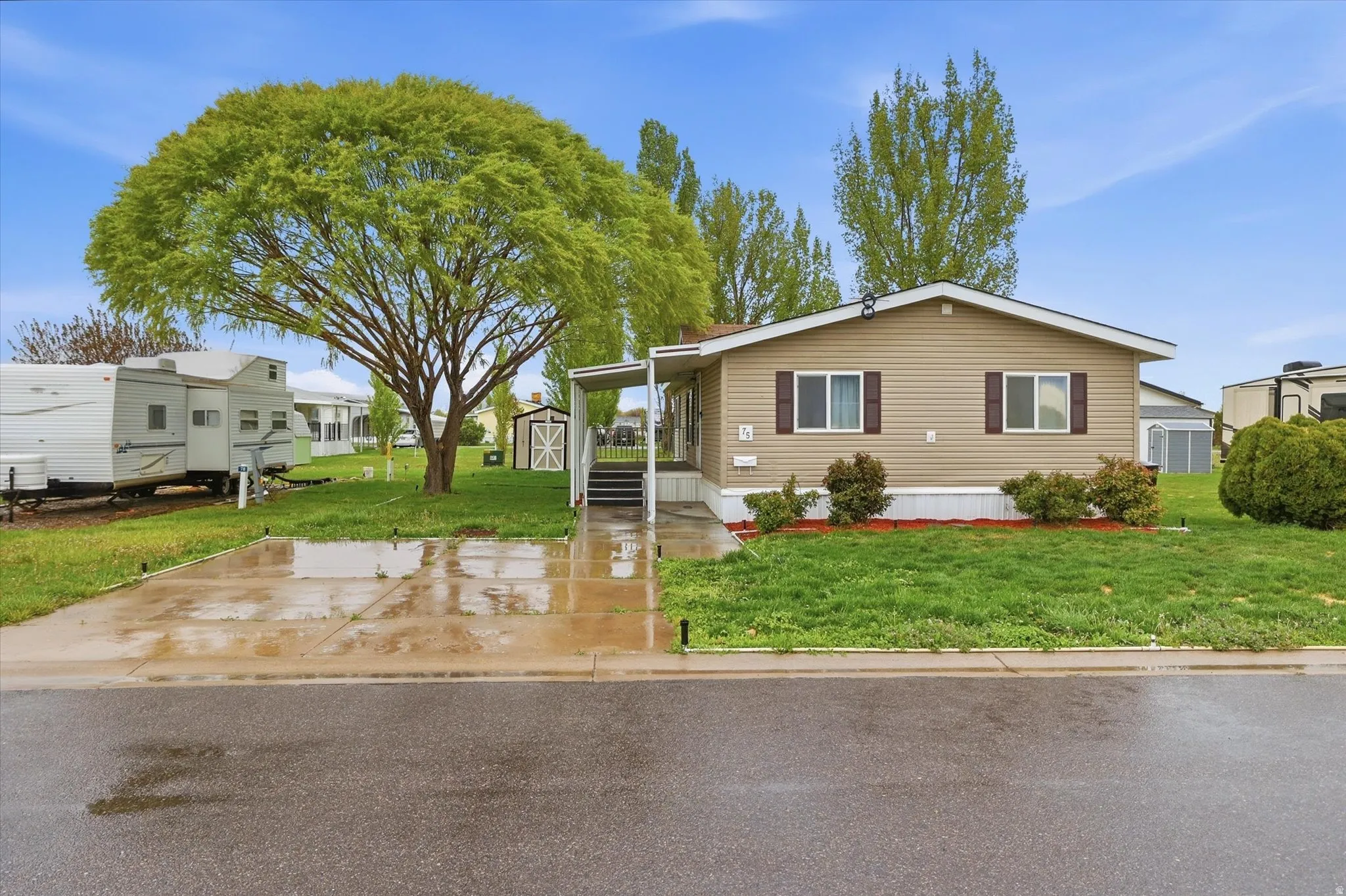 Manufactured / mobile home featuring a front yard and an outbuilding