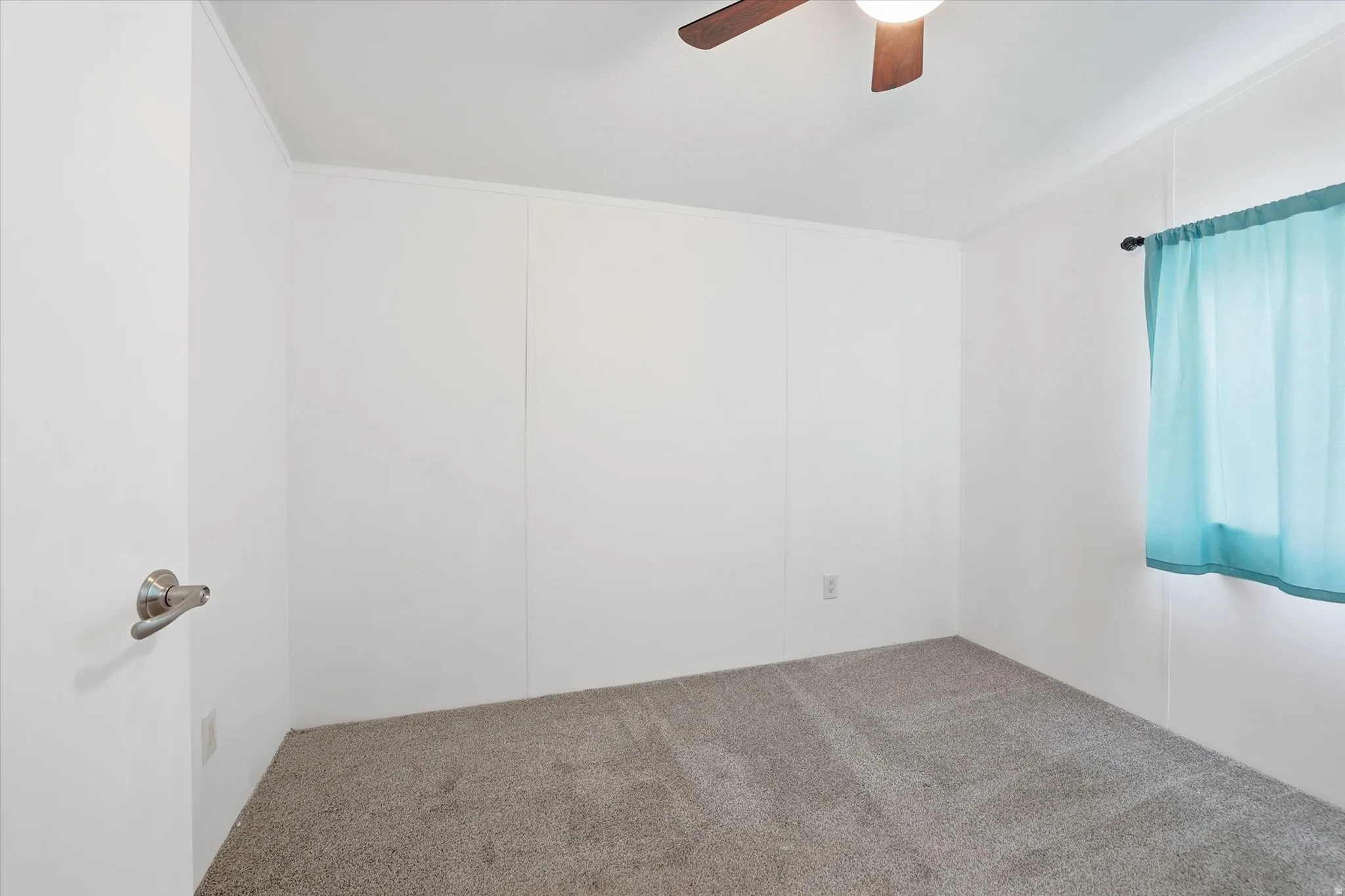 Carpeted empty room with a ceiling fan