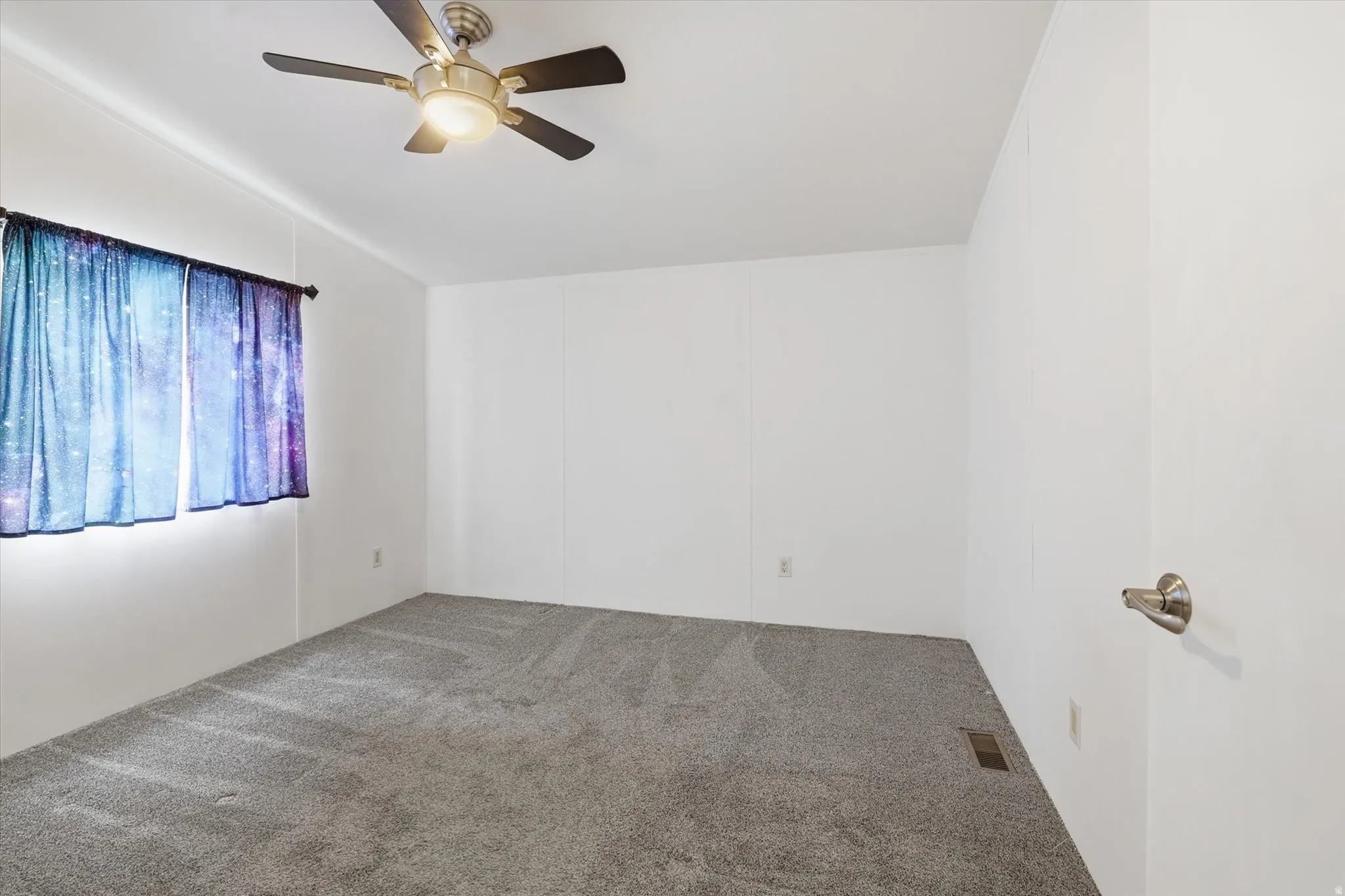 Carpeted empty room with a ceiling fan