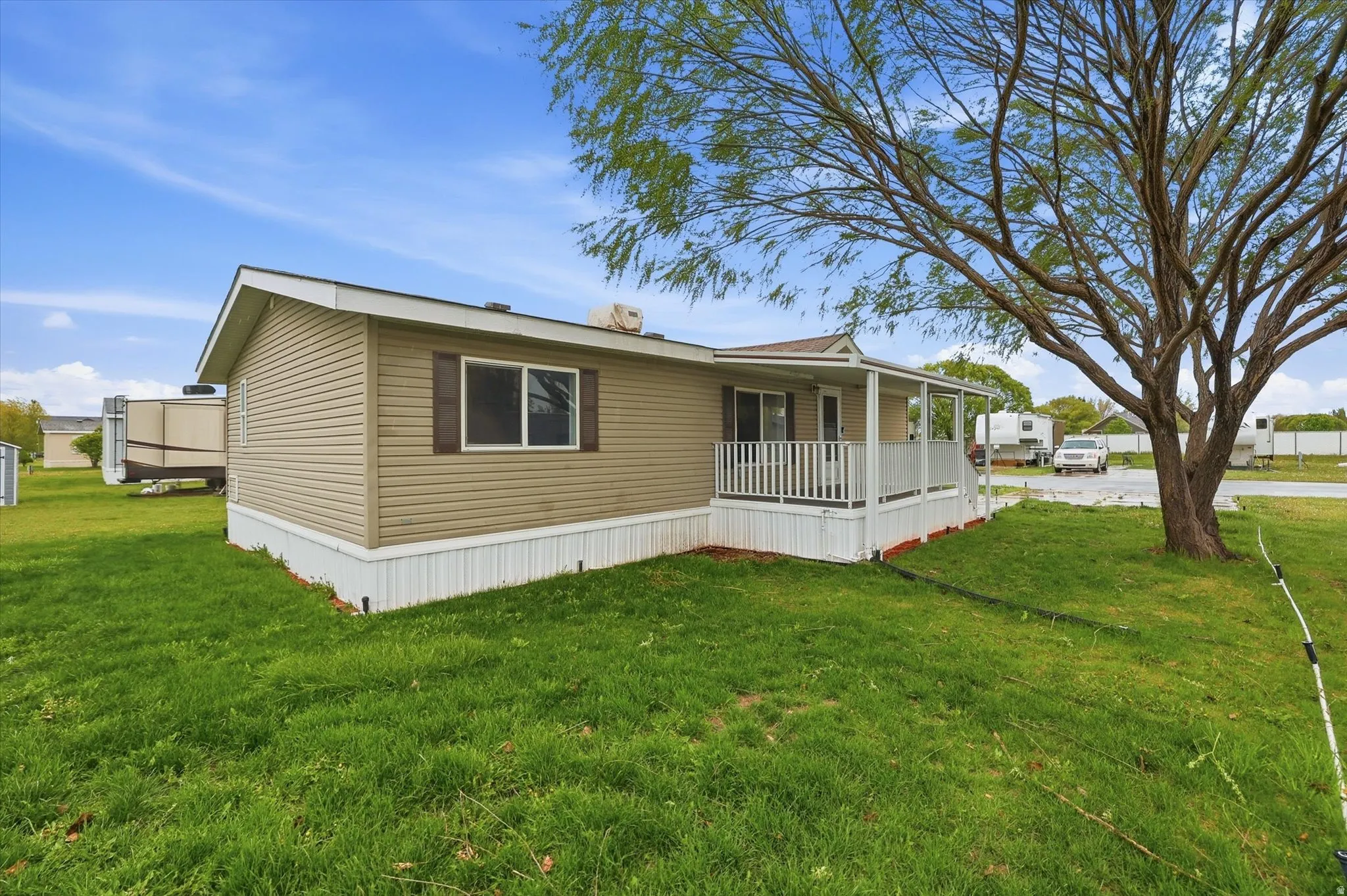View of front facade featuring covered porch and a front lawn
