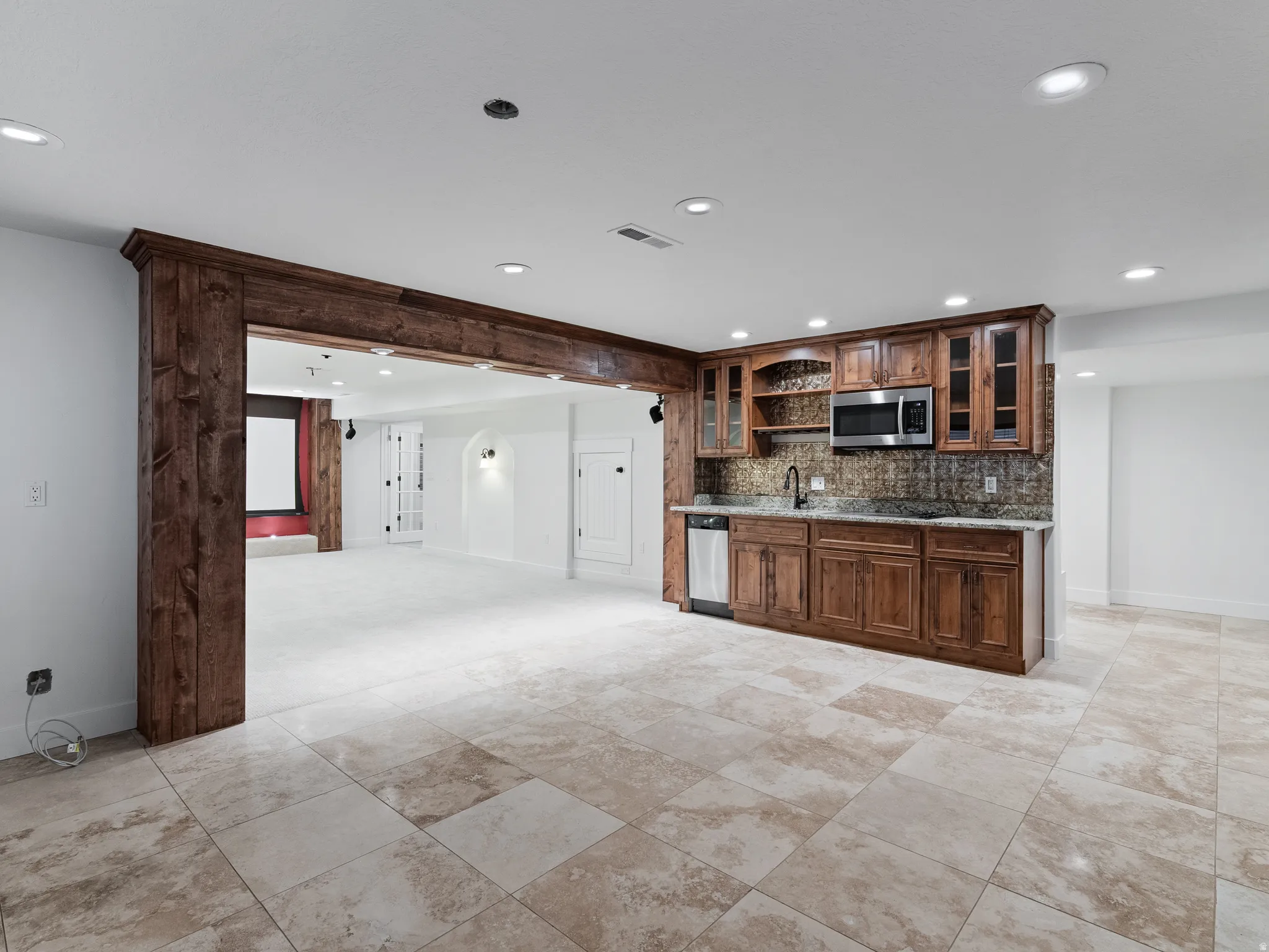 Kitchen with glass fronted cabinets, recessed lighting, decorative backsplash, dark stone counters, and open shelves