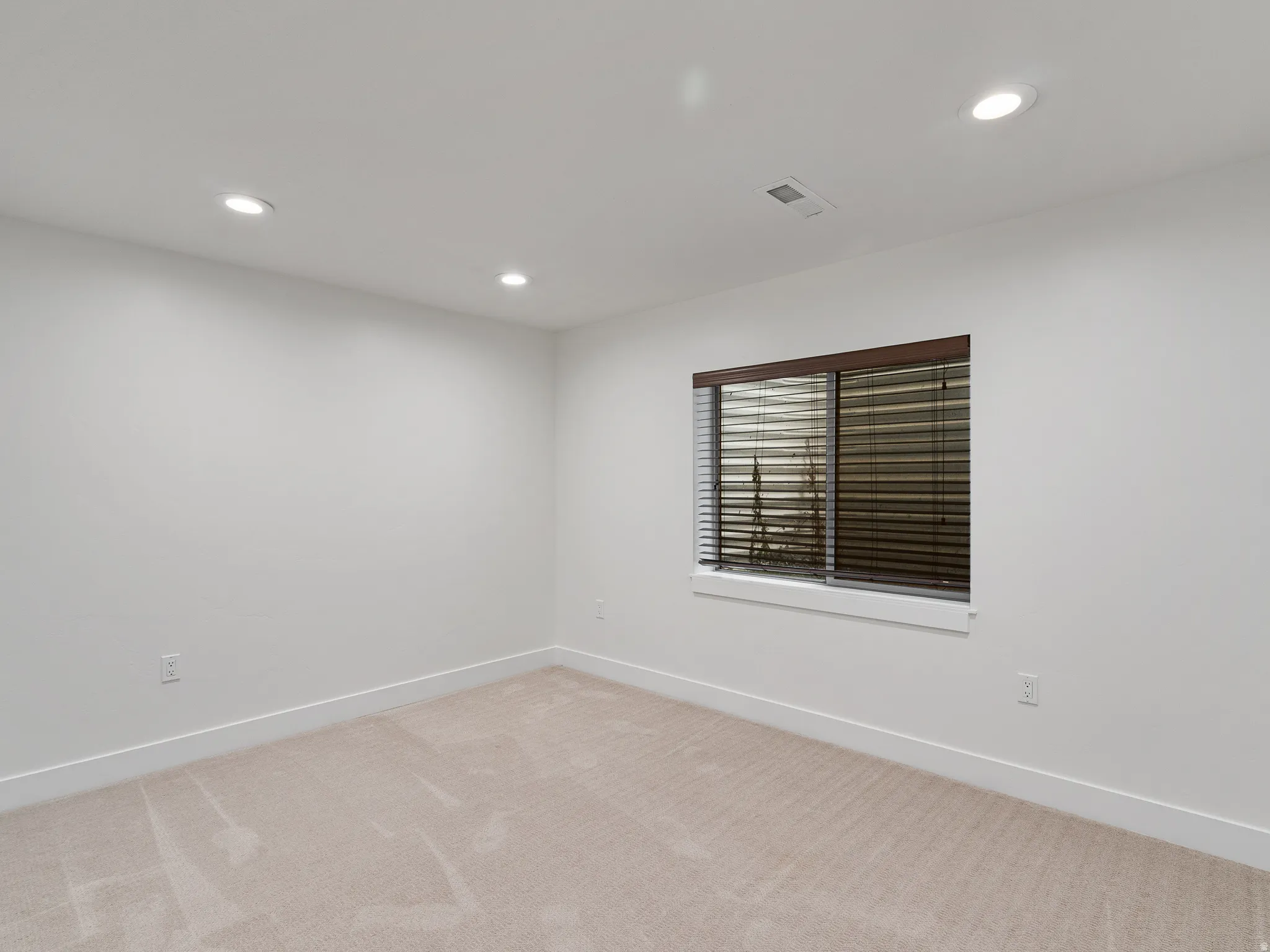 Empty room with recessed lighting and carpet floors