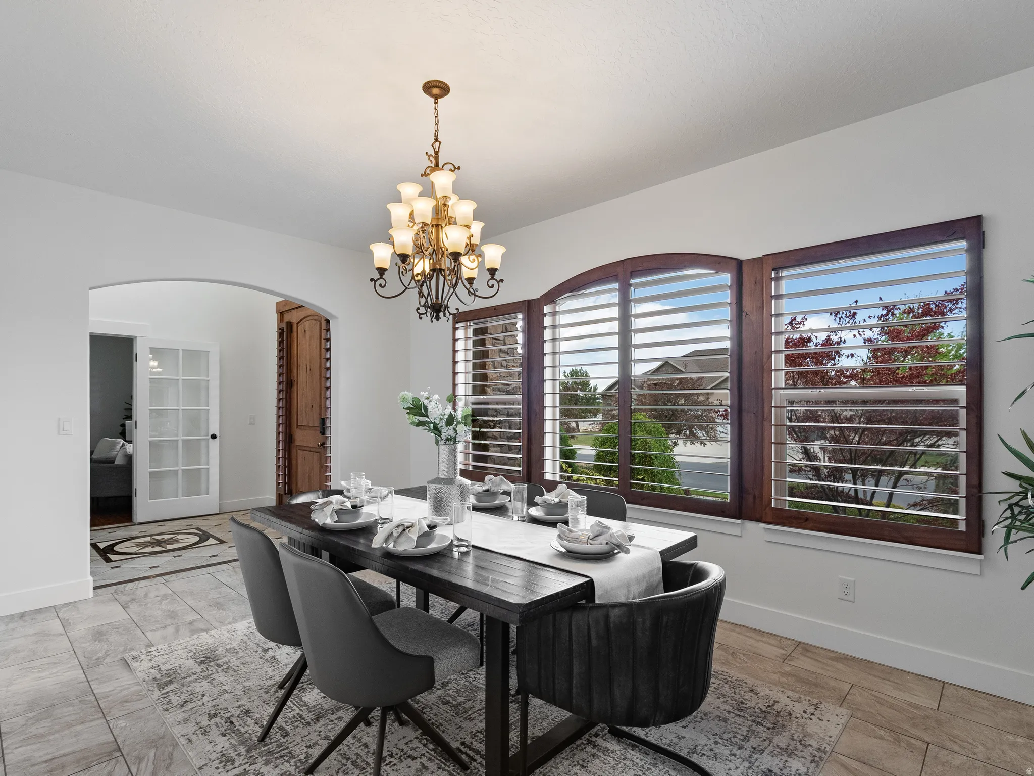 Dining space featuring arched walkways and a chandelier