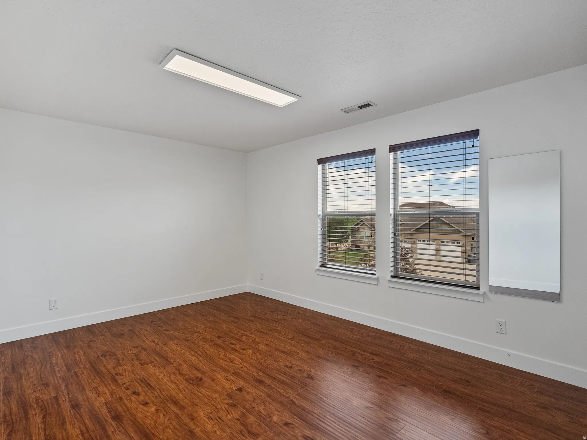 Empty room with baseboards and dark wood-style floors