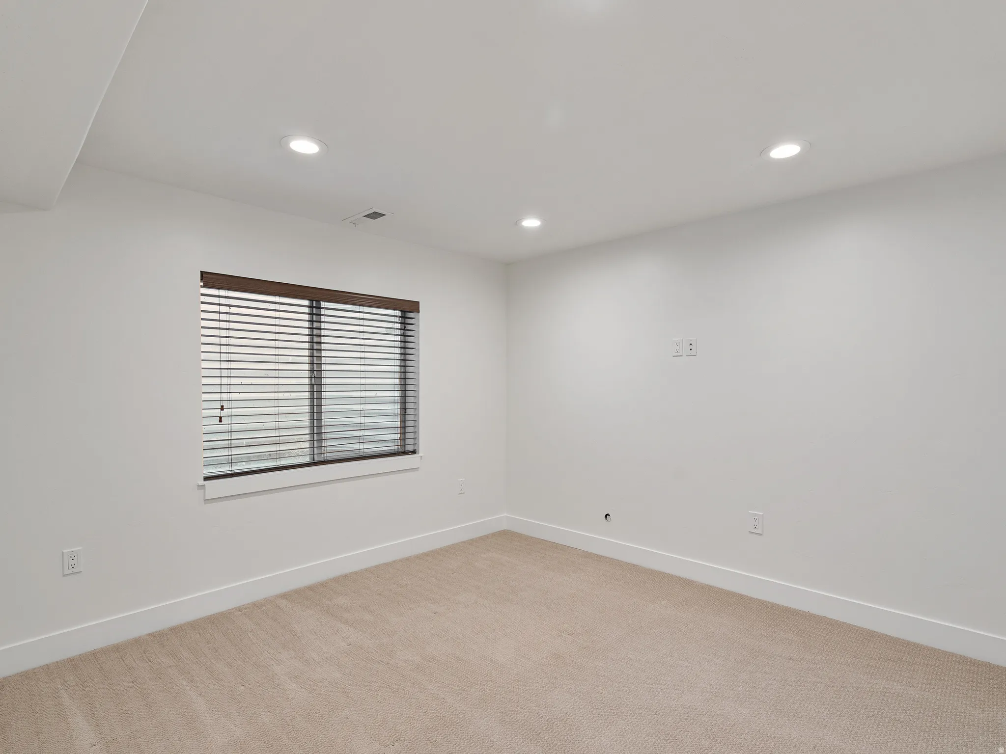 Spare room with light carpet and recessed lighting