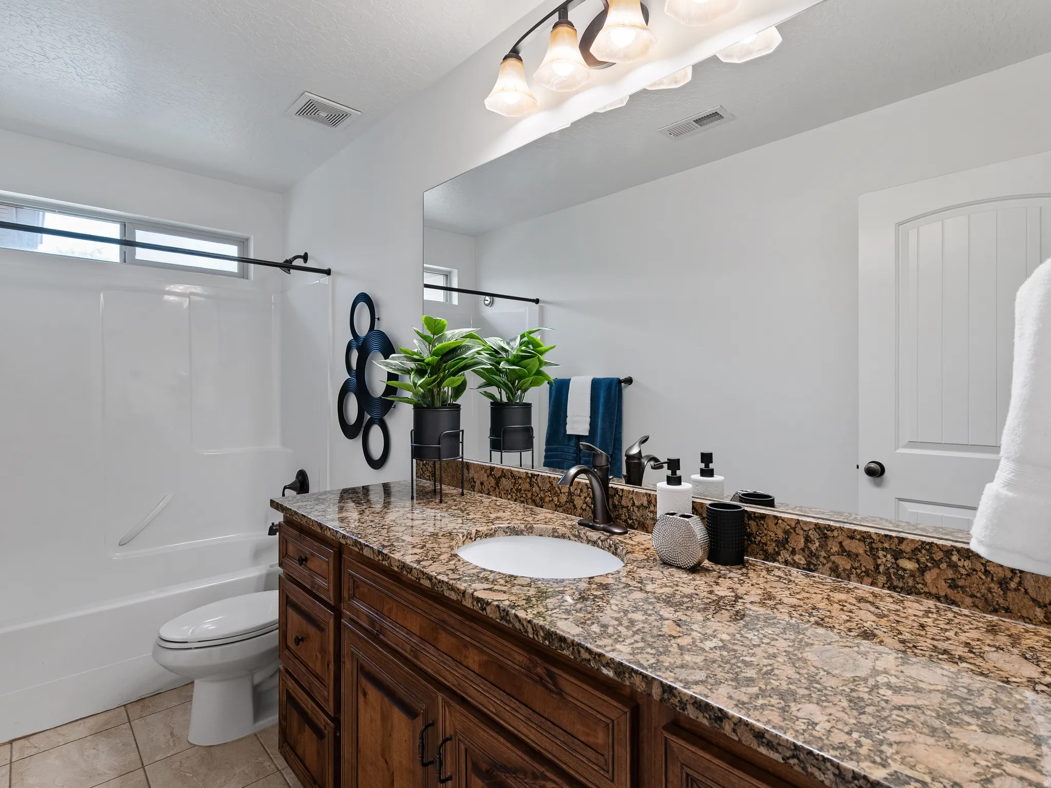 Full bathroom with vanity, washtub / shower combination, and light tile patterned flooring