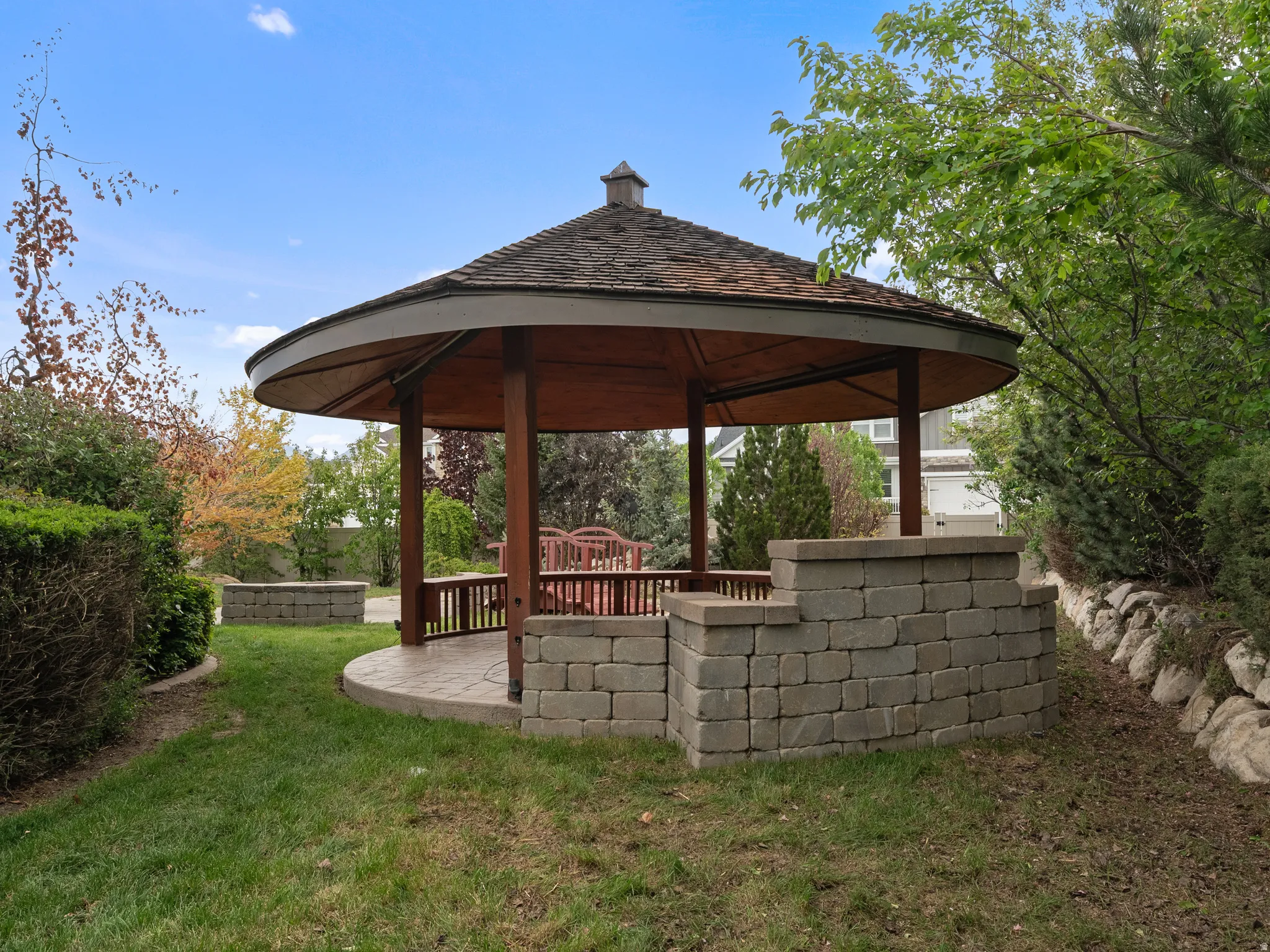 View of green lawn with a gazebo and a patio area