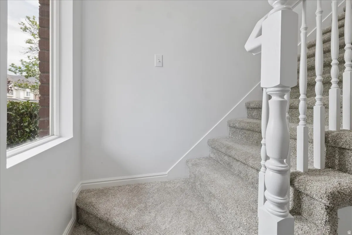 Stairway featuring baseboards and carpet flooring