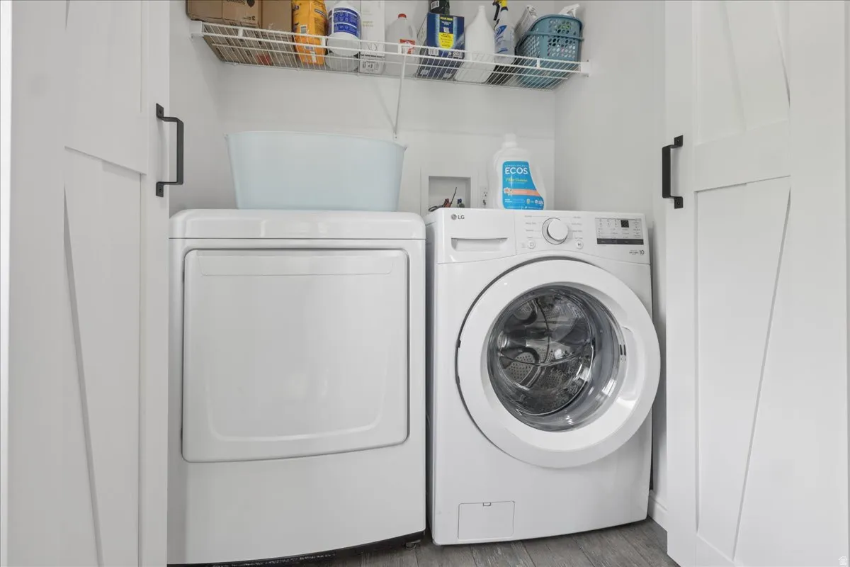 Laundry area featuring washer and dryer and wood finished floors