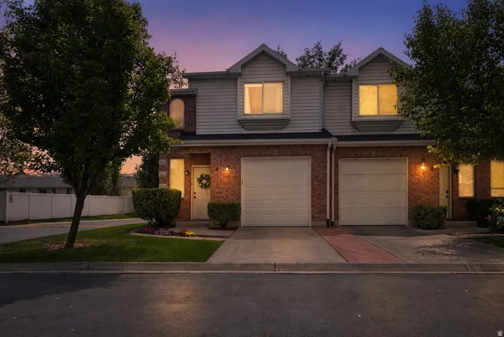 Traditional-style home featuring driveway, an attached garage, and brick siding
