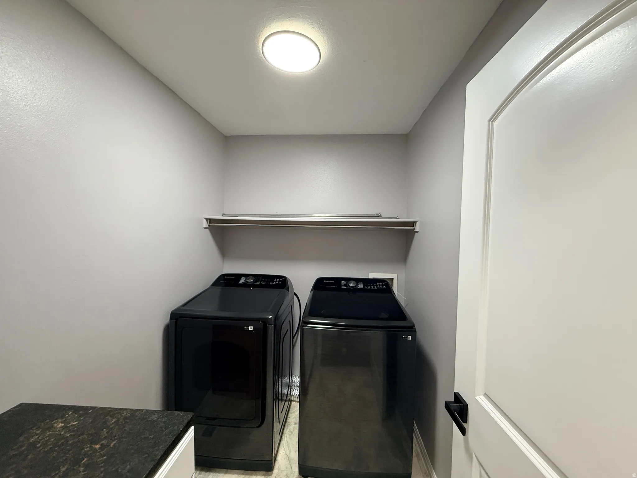 Dedicated utility space featuring a wall-mounted shelf, recessed ceiling light, and light gray walls