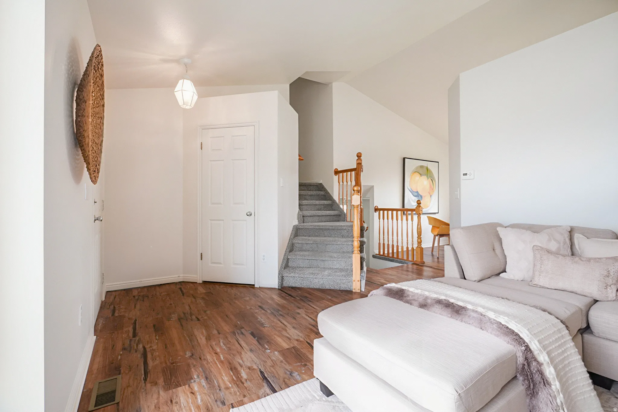 Living room featuring wood finished floors and vaulted ceiling