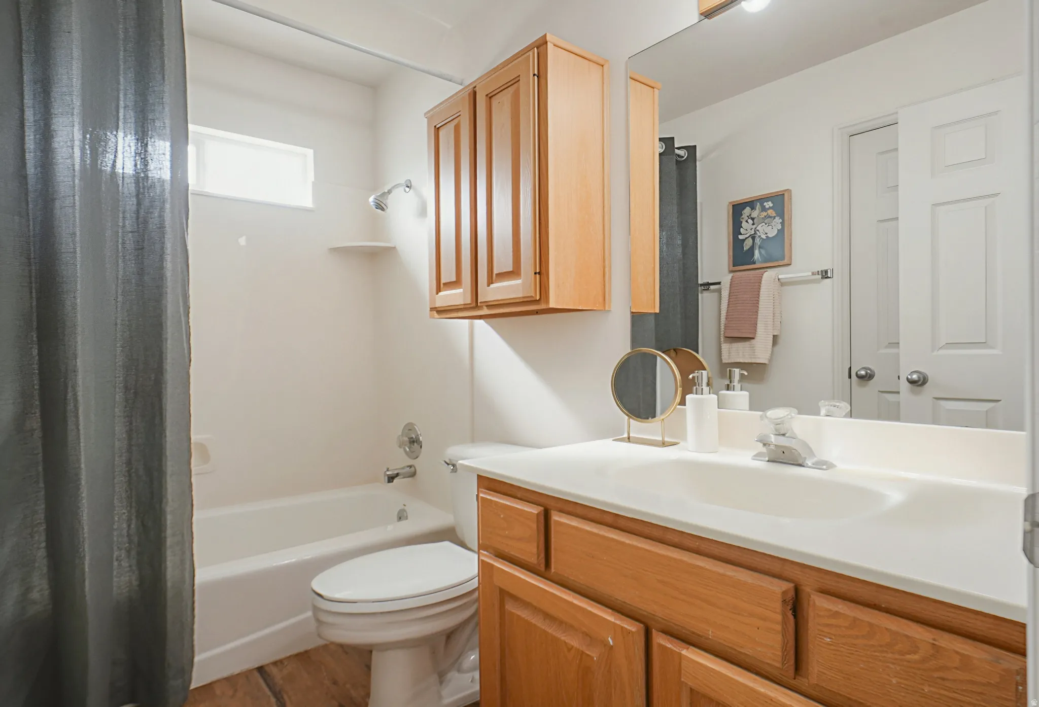 Bathroom featuring vanity, shower / tub combo with curtain, and light wood-style floors