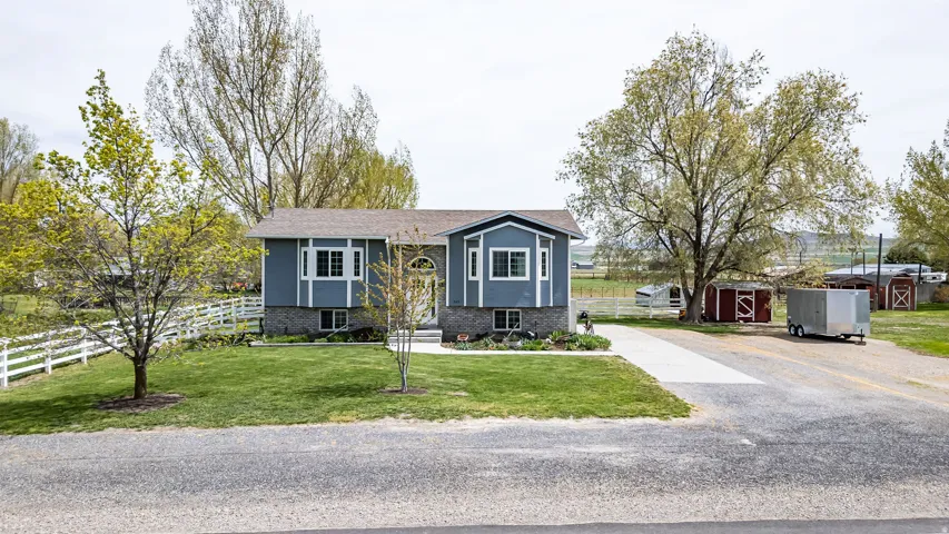 Bi-level home with brick siding, a storage shed, and driveway