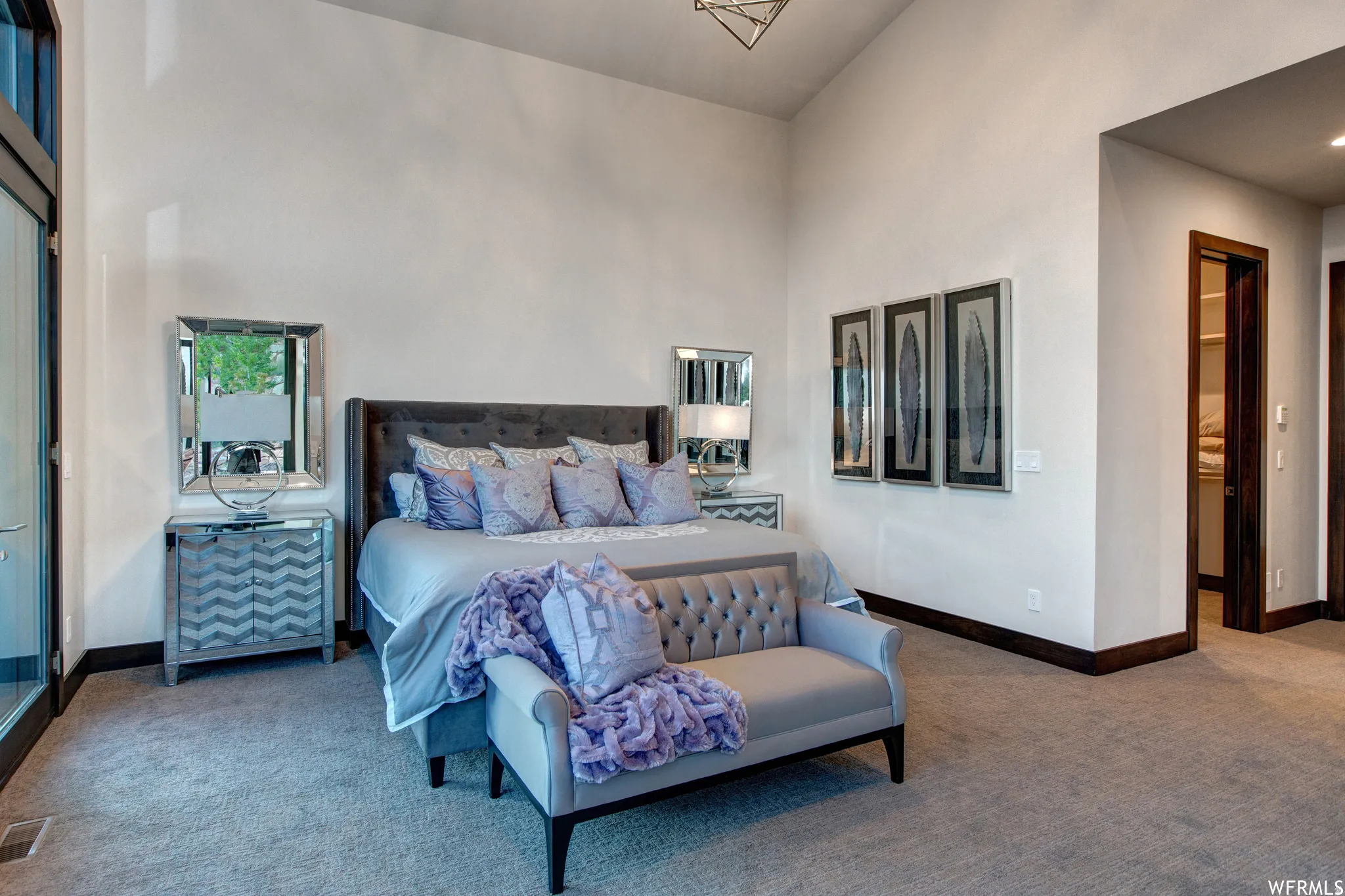 Carpeted bedroom featuring baseboards and vaulted ceiling