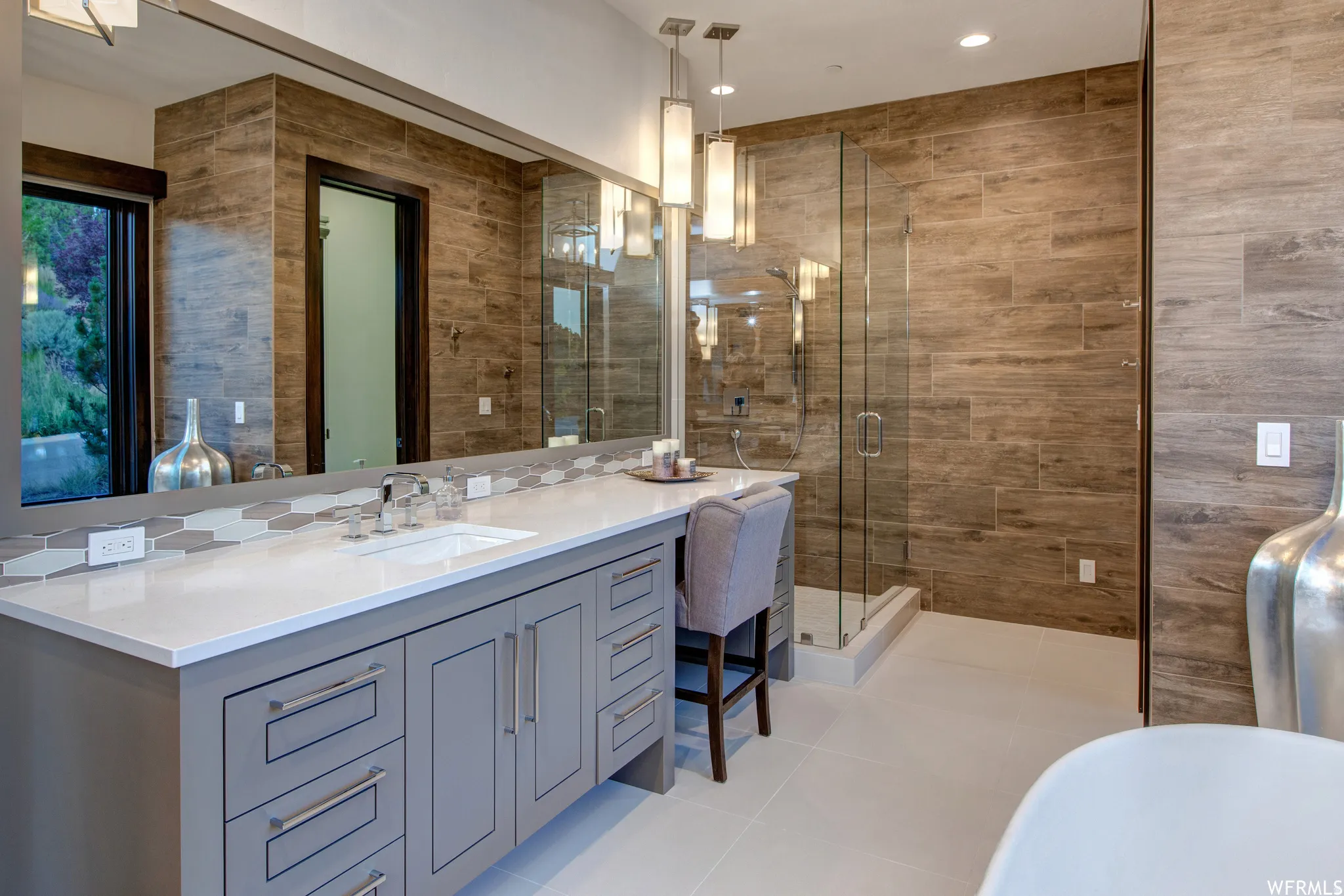 Bathroom with vanity, a stall shower, tile walls, light tile patterned floors, and a freestanding bath