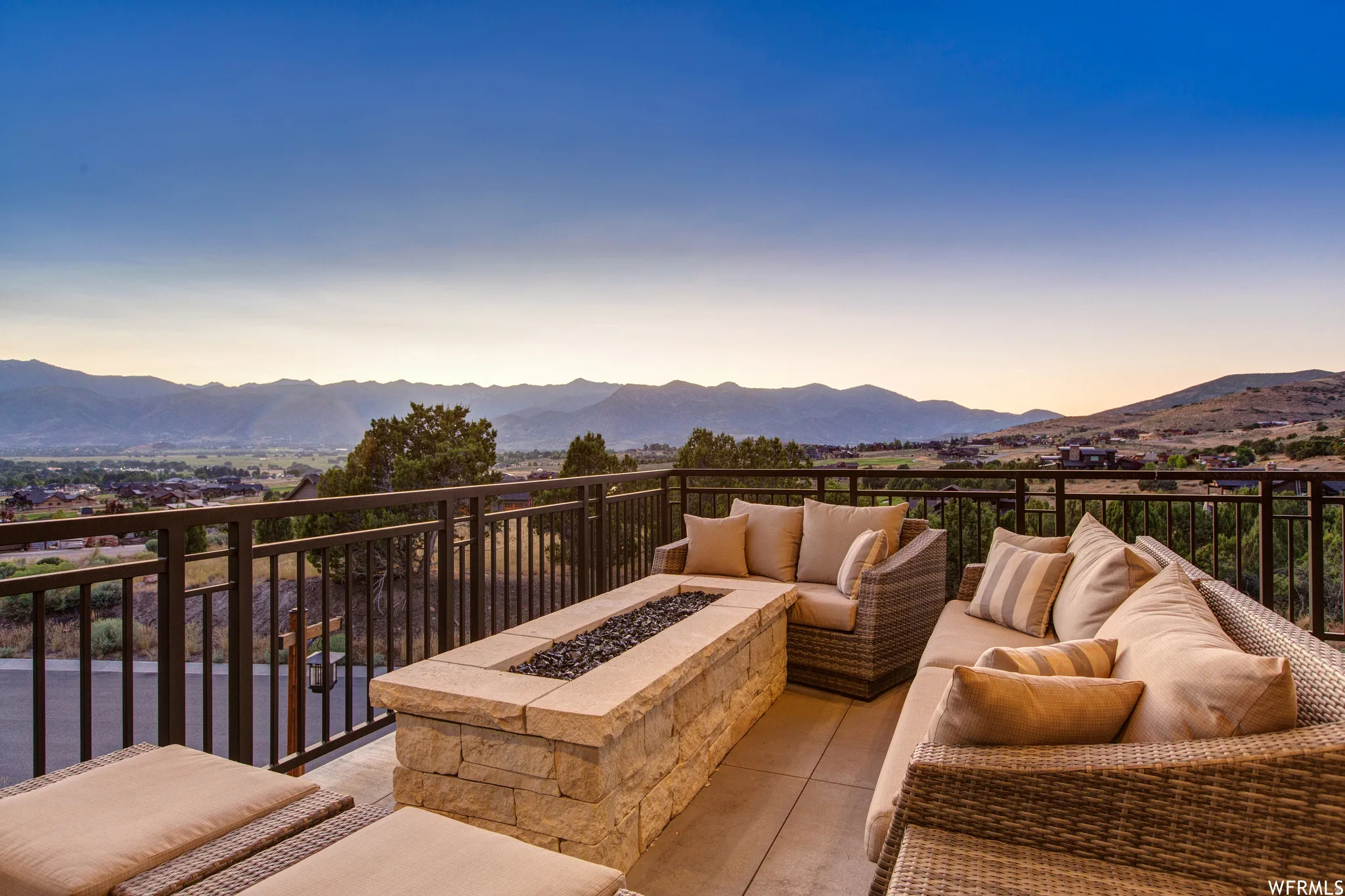 Patio terrace at dusk featuring a mountain view, a patio, and an outdoor living space with a fire pit