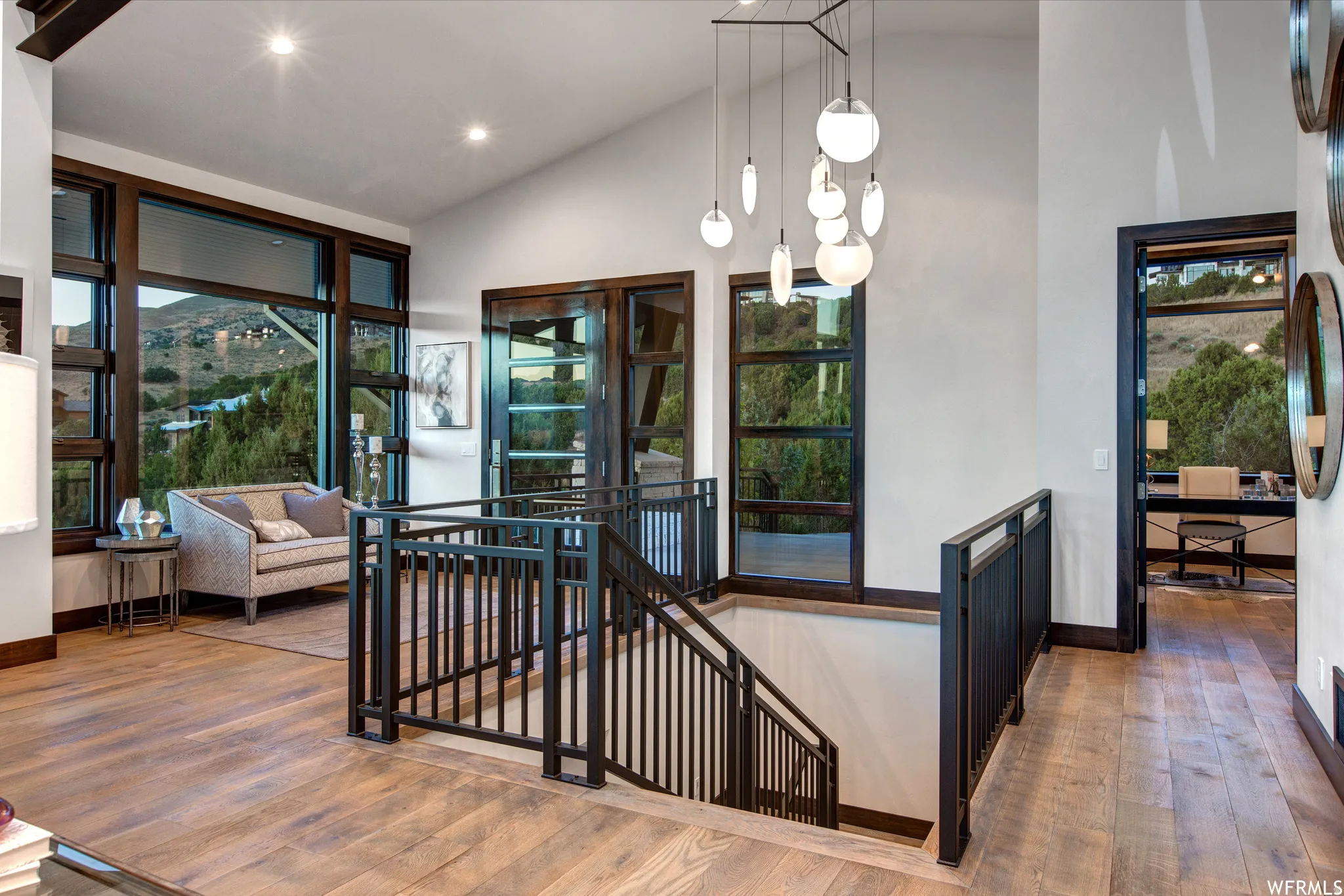 Stairway featuring hardwood / wood-style flooring, a high ceiling, a mountain view, and recessed lighting