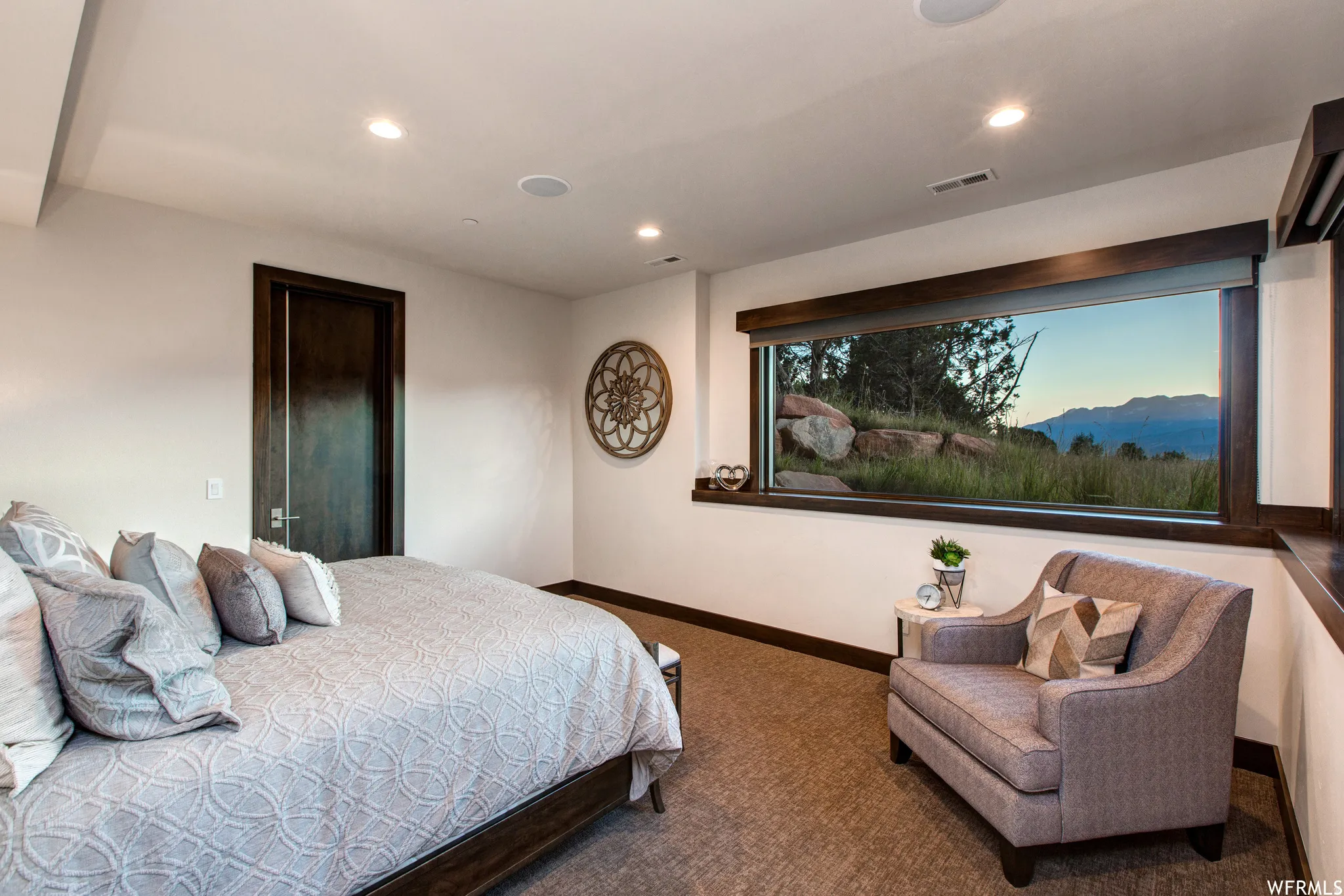 Carpeted bedroom with a mountain view and recessed lighting