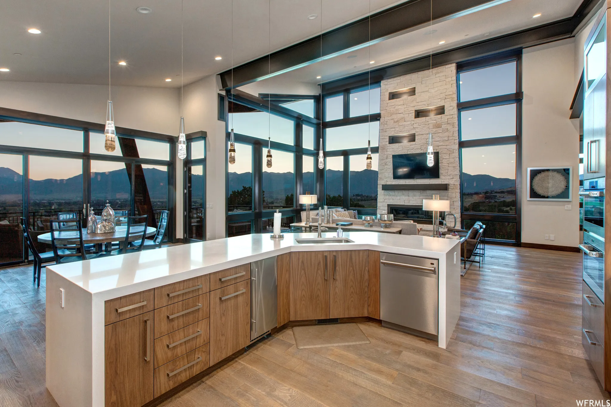 Kitchen featuring open floor plan, a mountain view, a high ceiling, light wood-type flooring, and modern cabinets