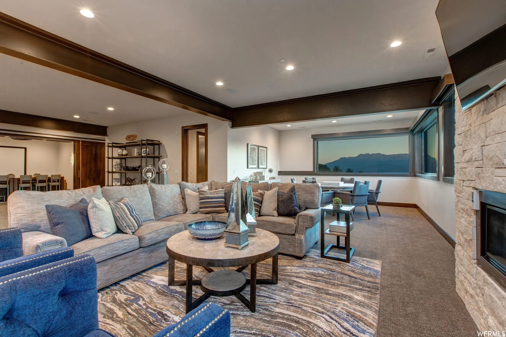 Living room featuring carpet flooring, a stone fireplace, recessed lighting, and ornamental molding