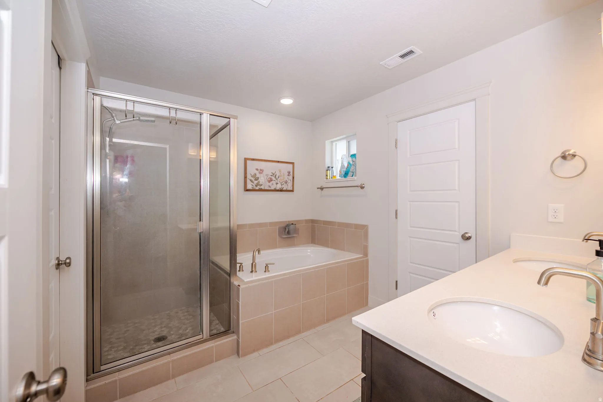 Full bathroom with double vanity, a stall shower, a garden tub, light tile patterned flooring, and recessed lighting