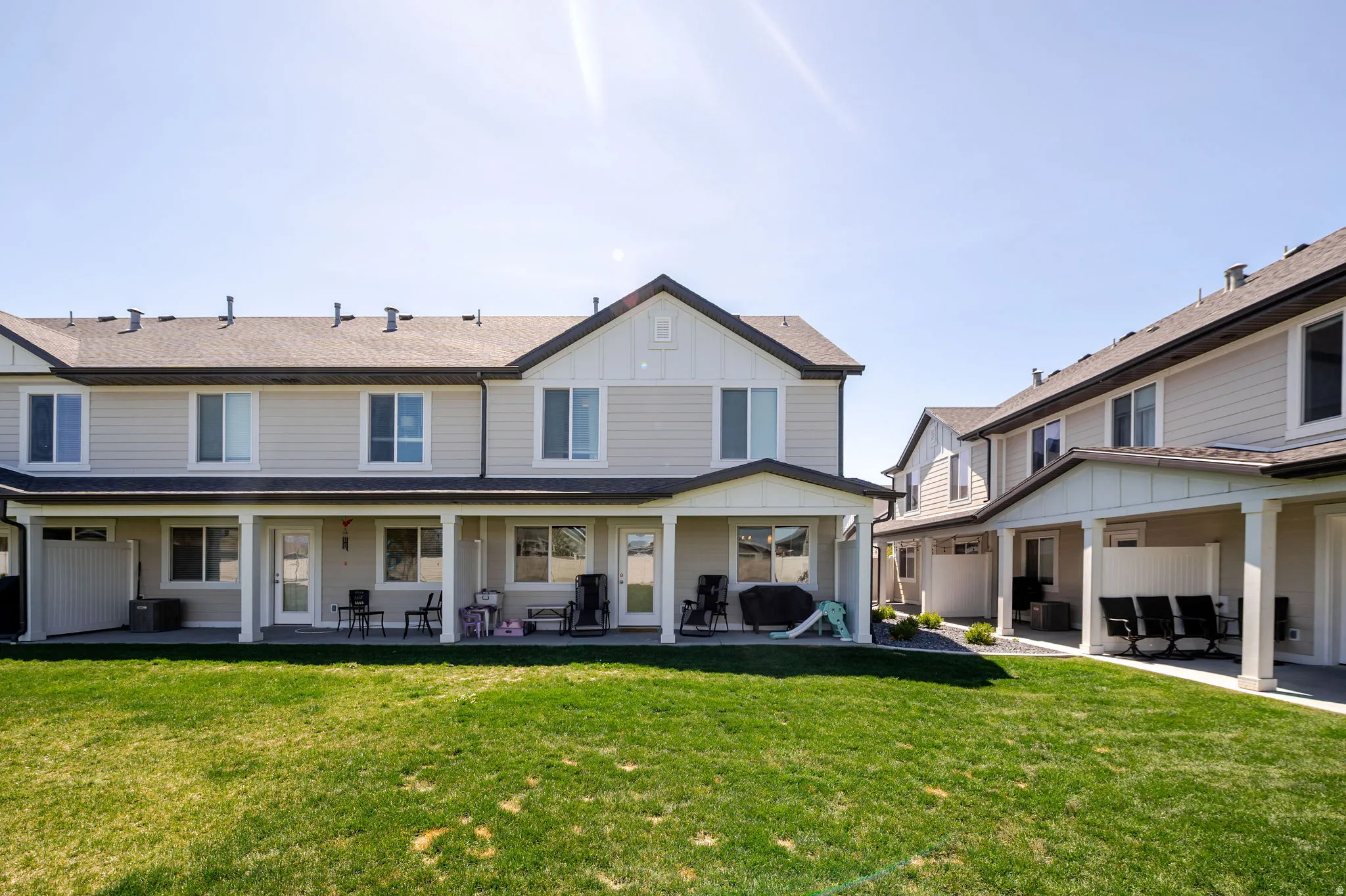 Rear view of house featuring a lawn, a patio, and board and batten siding