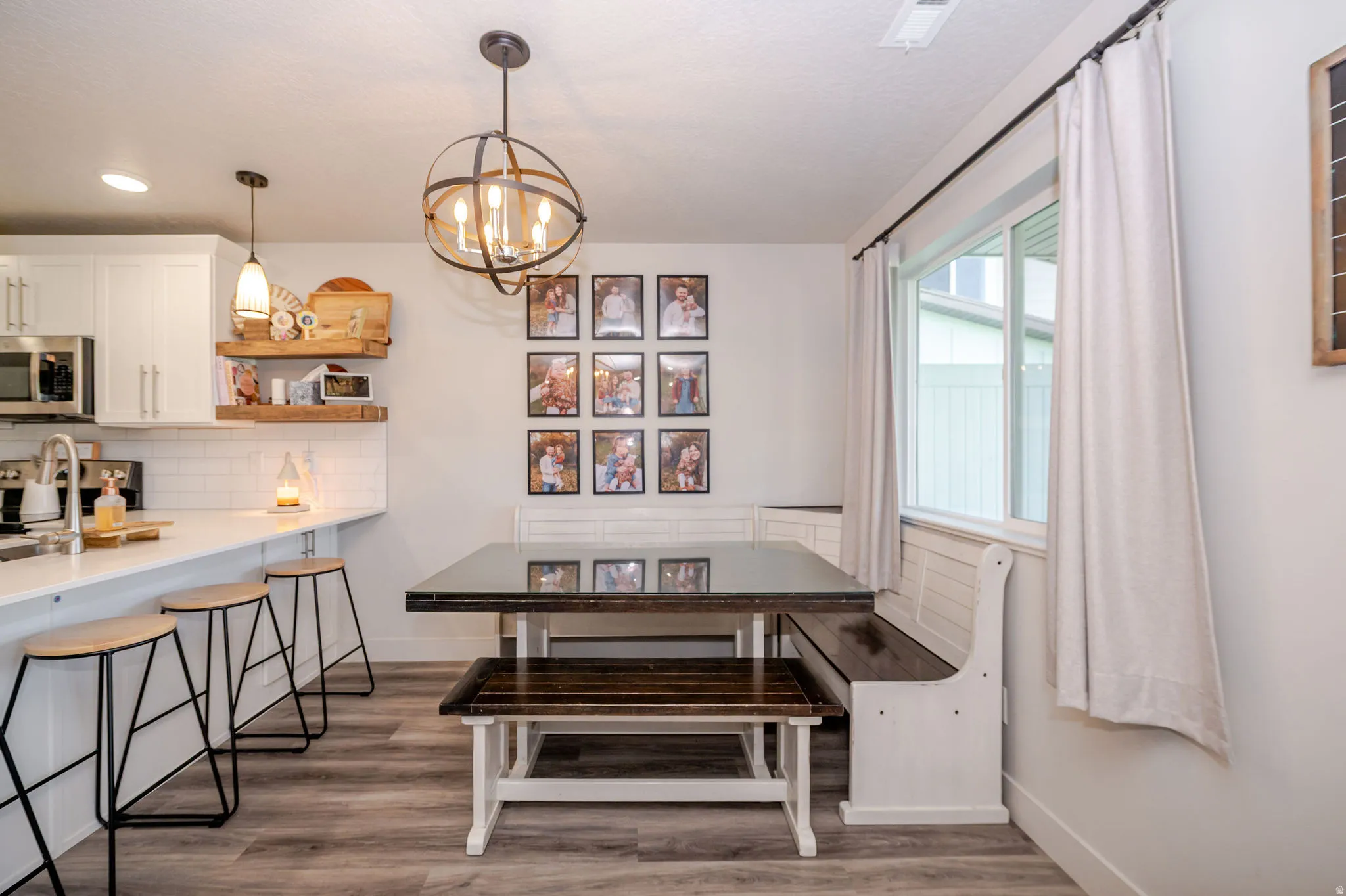 Dining space featuring dark wood-style flooring, hanging lights, and breakfast area