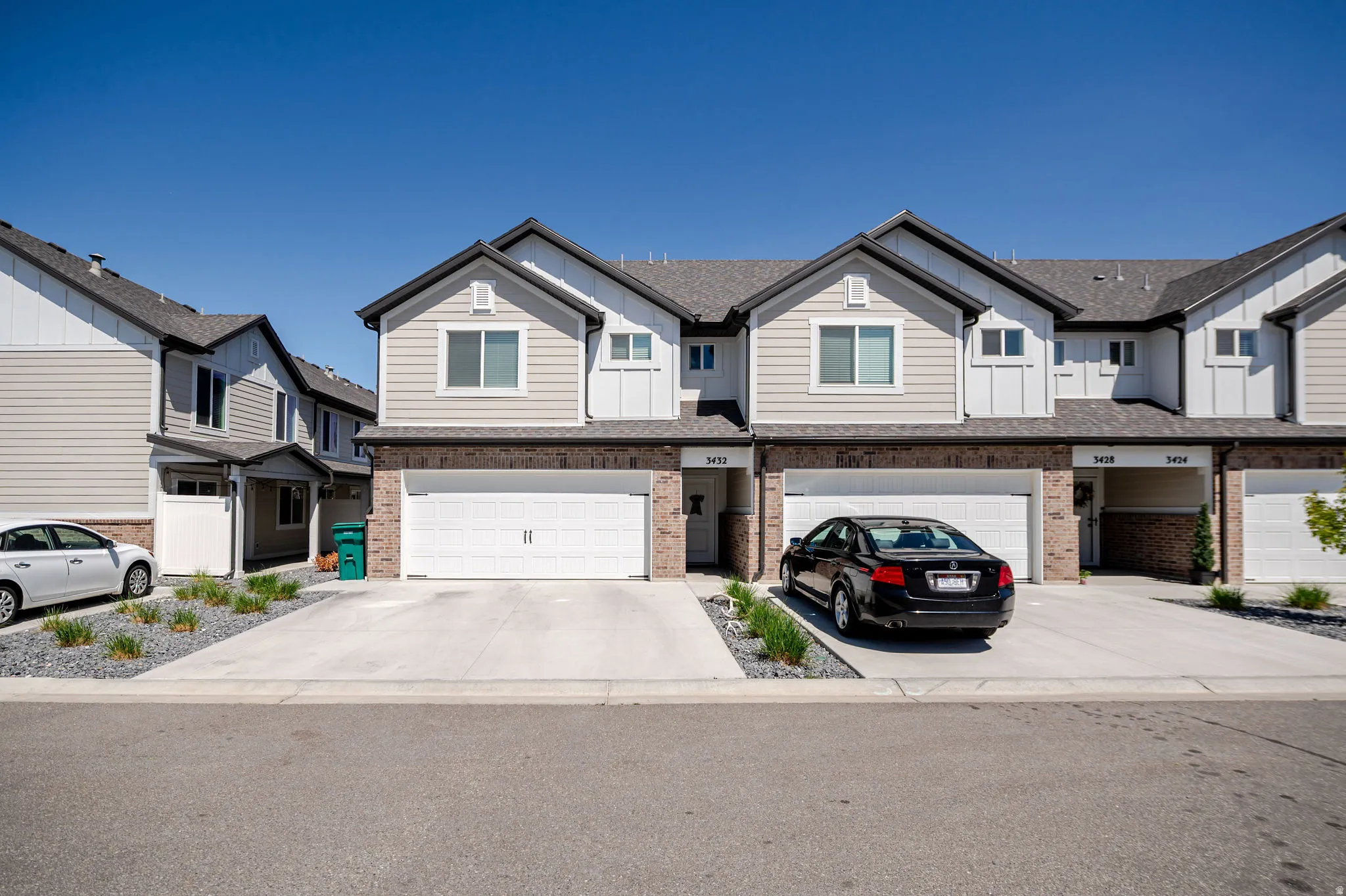 View of front of home with board and batten siding, a residential view, brick siding, and an attached garage
