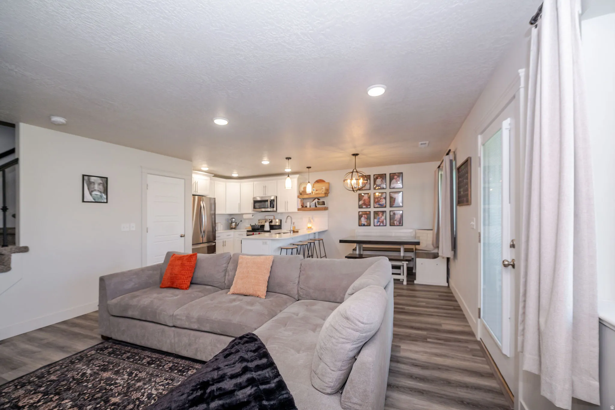 Living room with dark wood-style floors and a chandelier