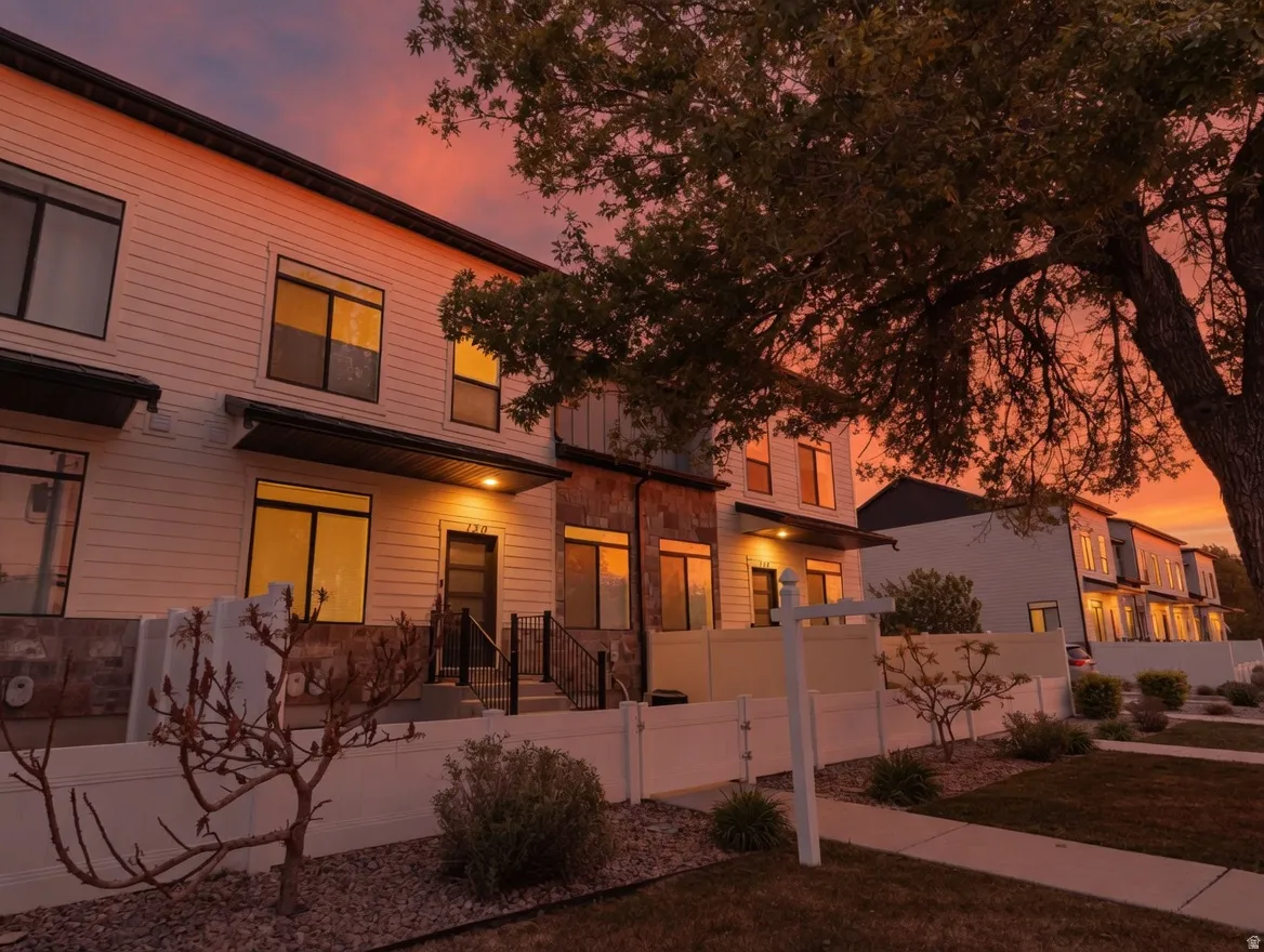 Modern home with a fenced front yard, a gate, and stone siding