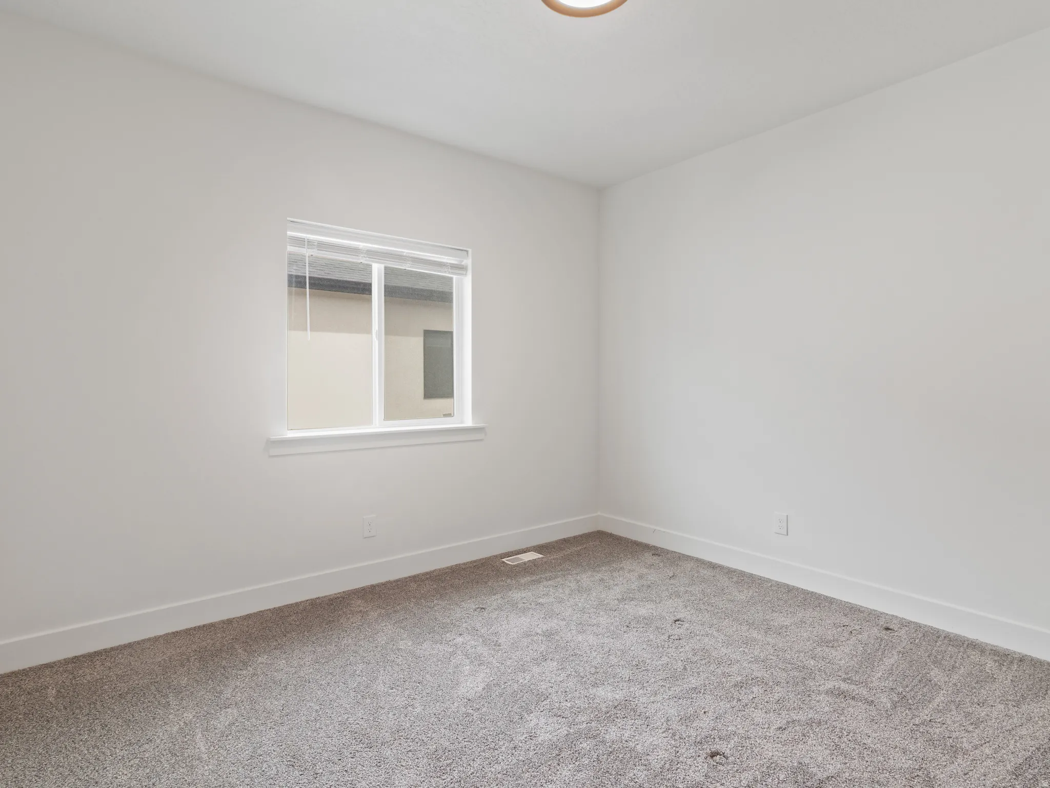 Spare room with light carpet and baseboards