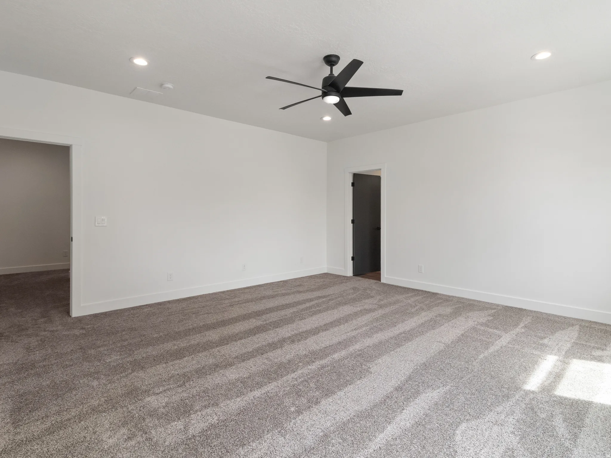 Carpeted spare room featuring a ceiling fan and recessed lighting