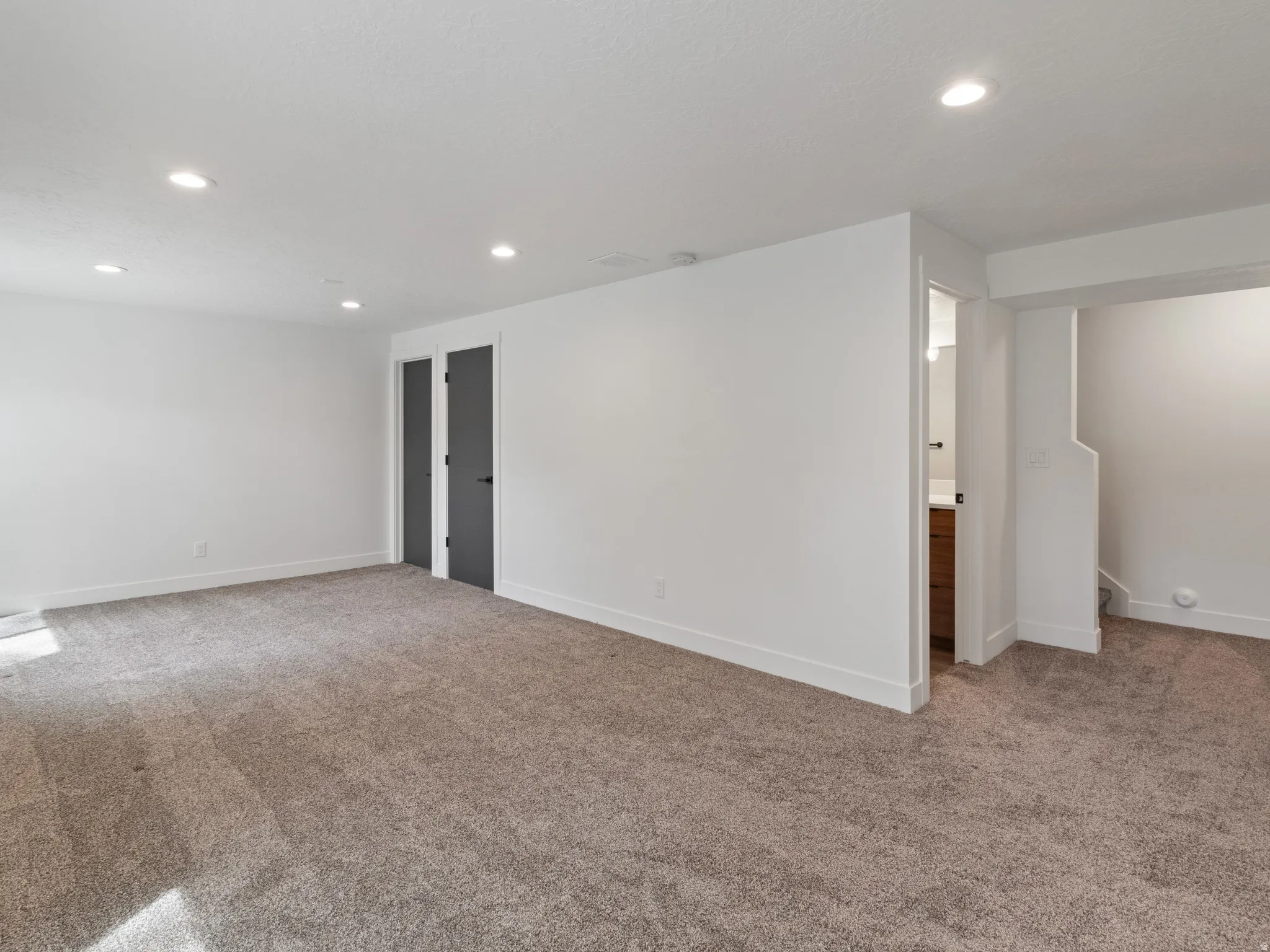 Empty room featuring light colored carpet and recessed lighting