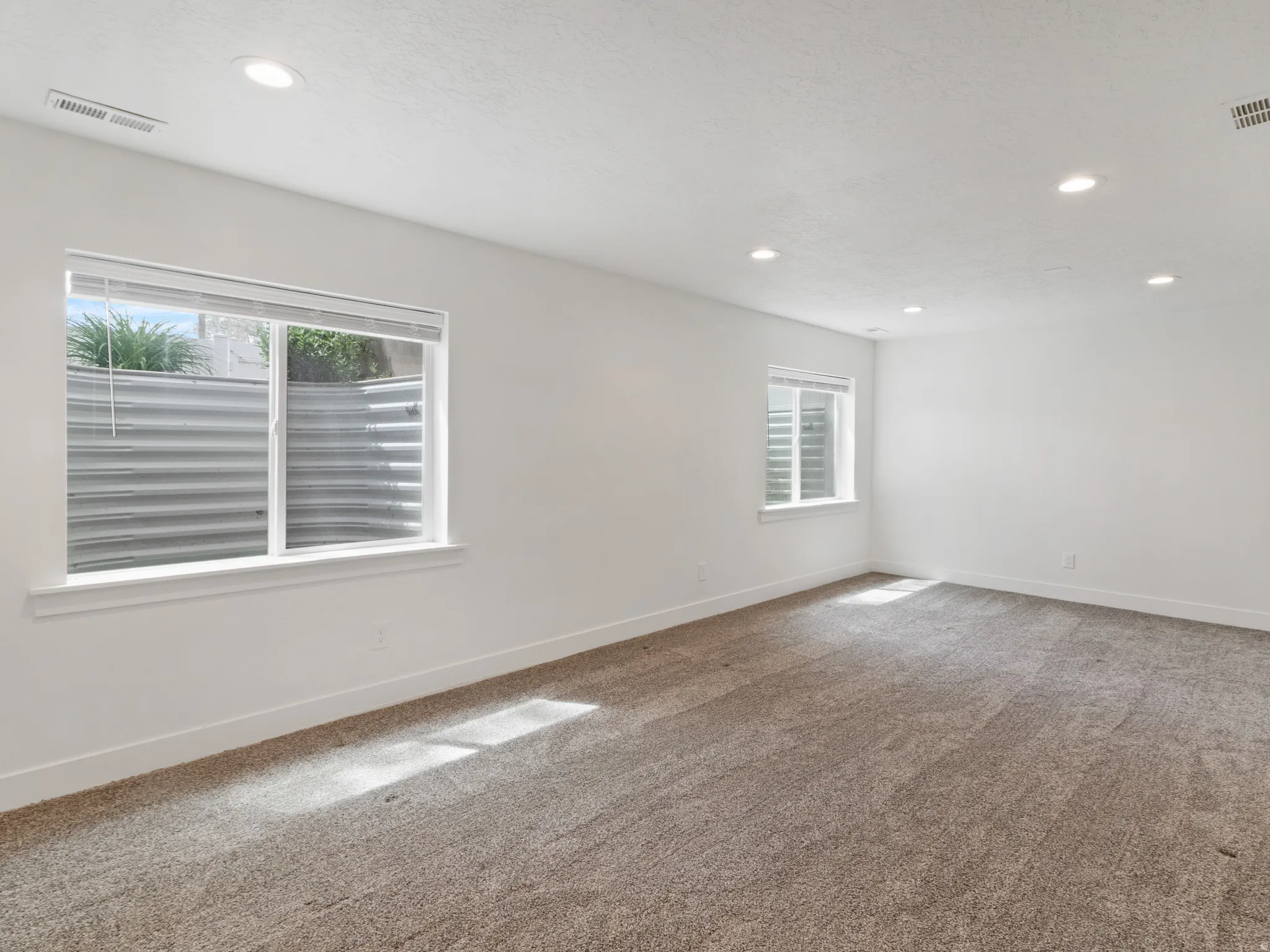 Carpeted empty room with recessed lighting