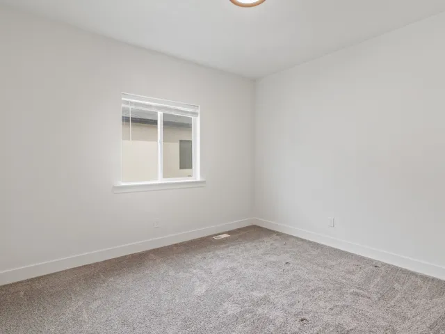 Spare room with light carpet and baseboards