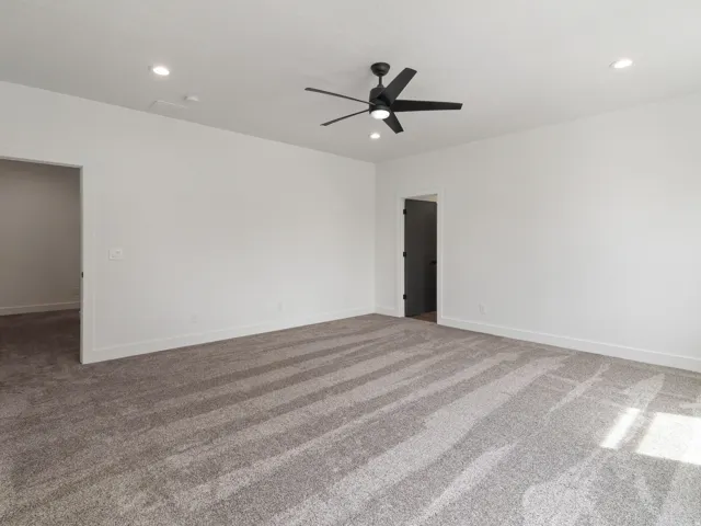 Carpeted spare room featuring a ceiling fan and recessed lighting